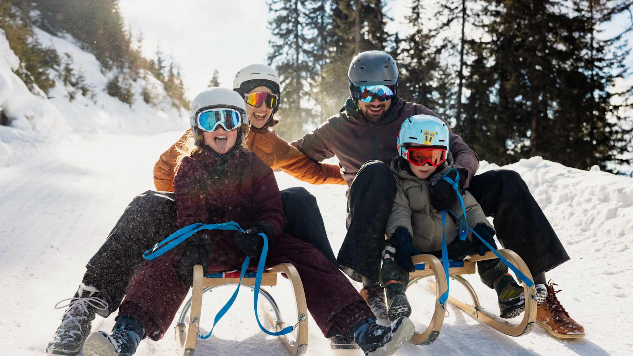 Bild von Familie auf Schlitten.
