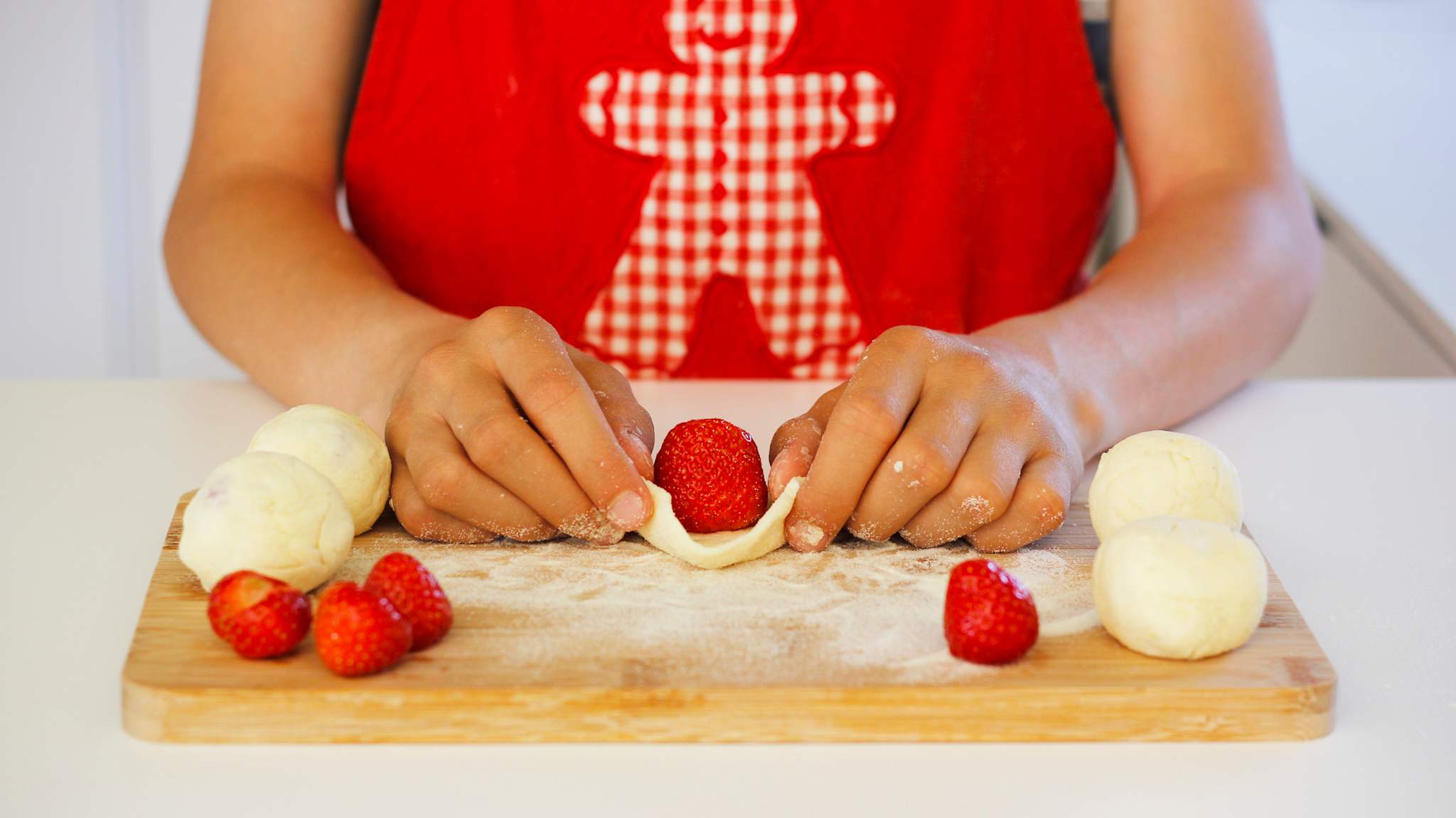 Eine Frau arbeitet Erdbeeren in Knödel ein für die süßen, fruchtigen tschechischen Knödel Ovocné knedlíky.