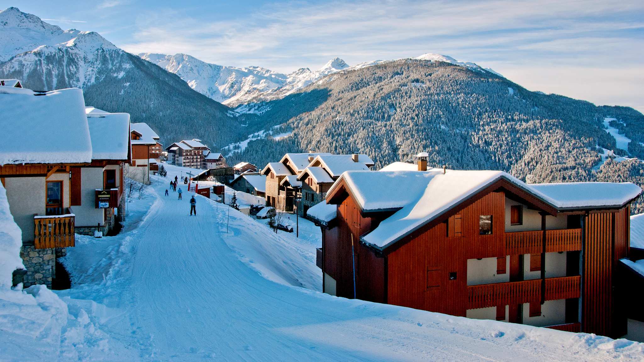 Holzgetäfelte Häuser am Rande einer Ski-befahrbarer Piste in Les Arcs in den französischen Alpen.