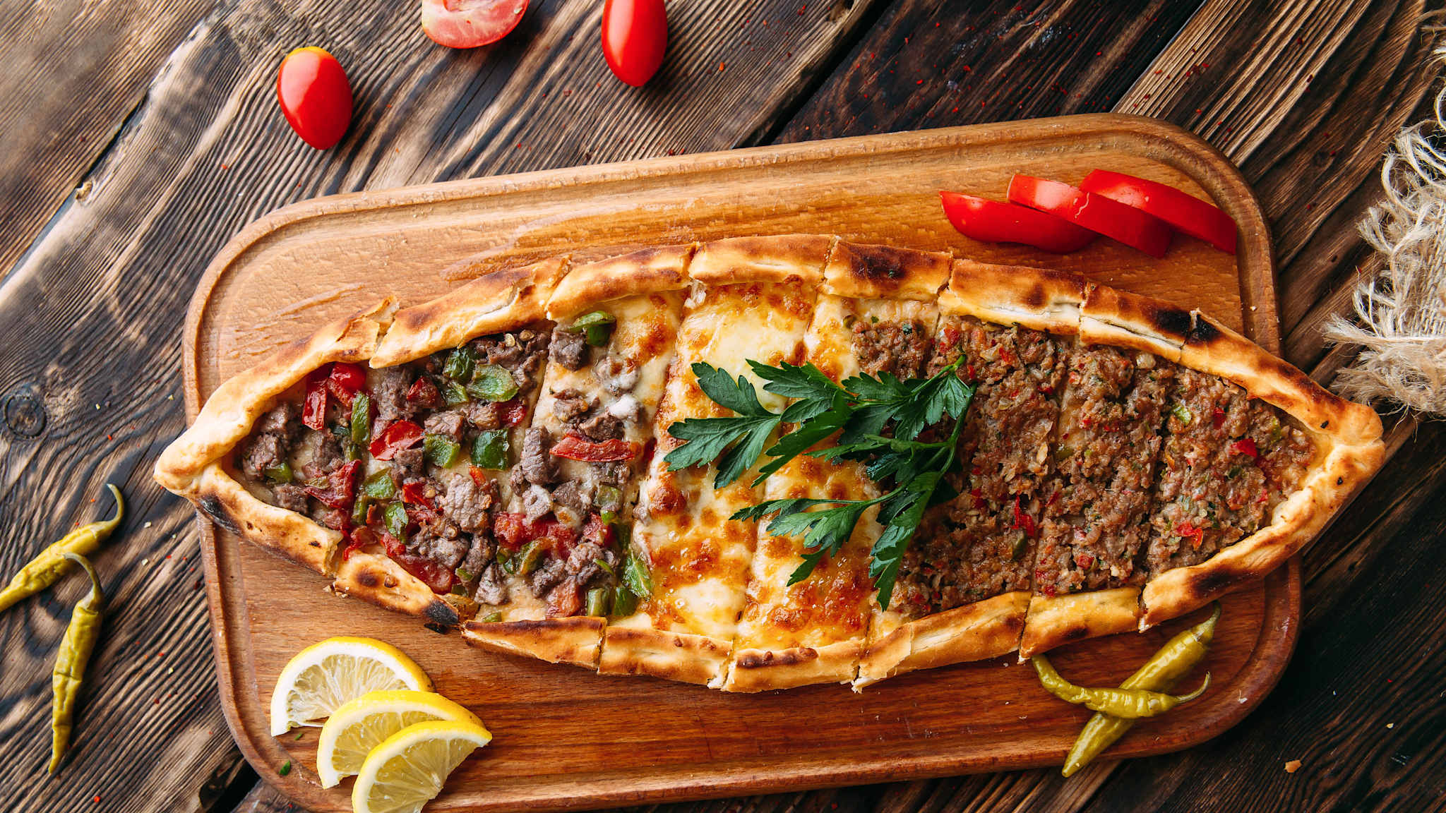 Blick von oben auf Pide mit Hackfleisch auf einem Holzbrett