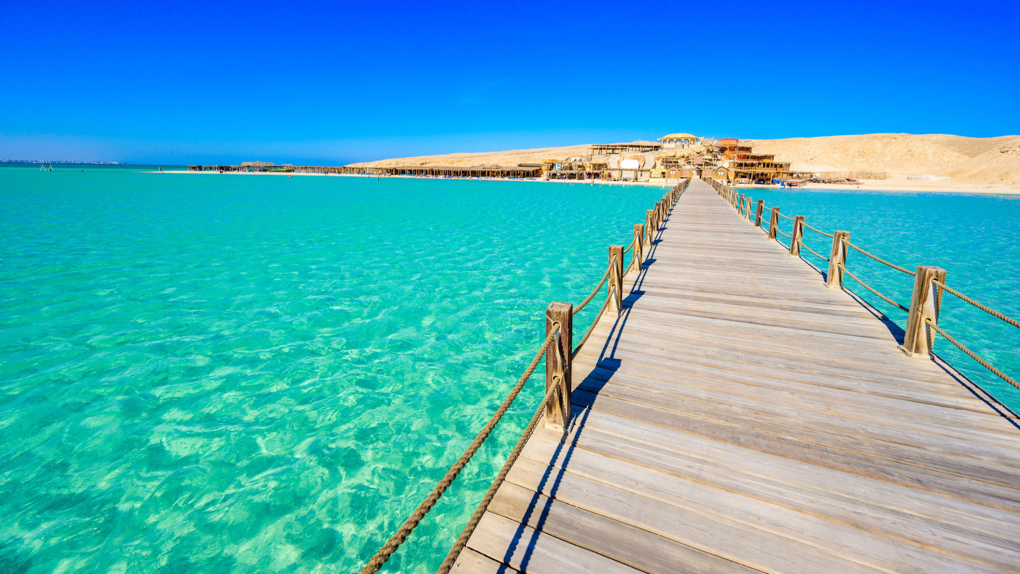 Pier auf den Giftun Inseln mit kristallklarem azurblauem Wasser und weißem Strand © iStock.com/Simon Dannhauer