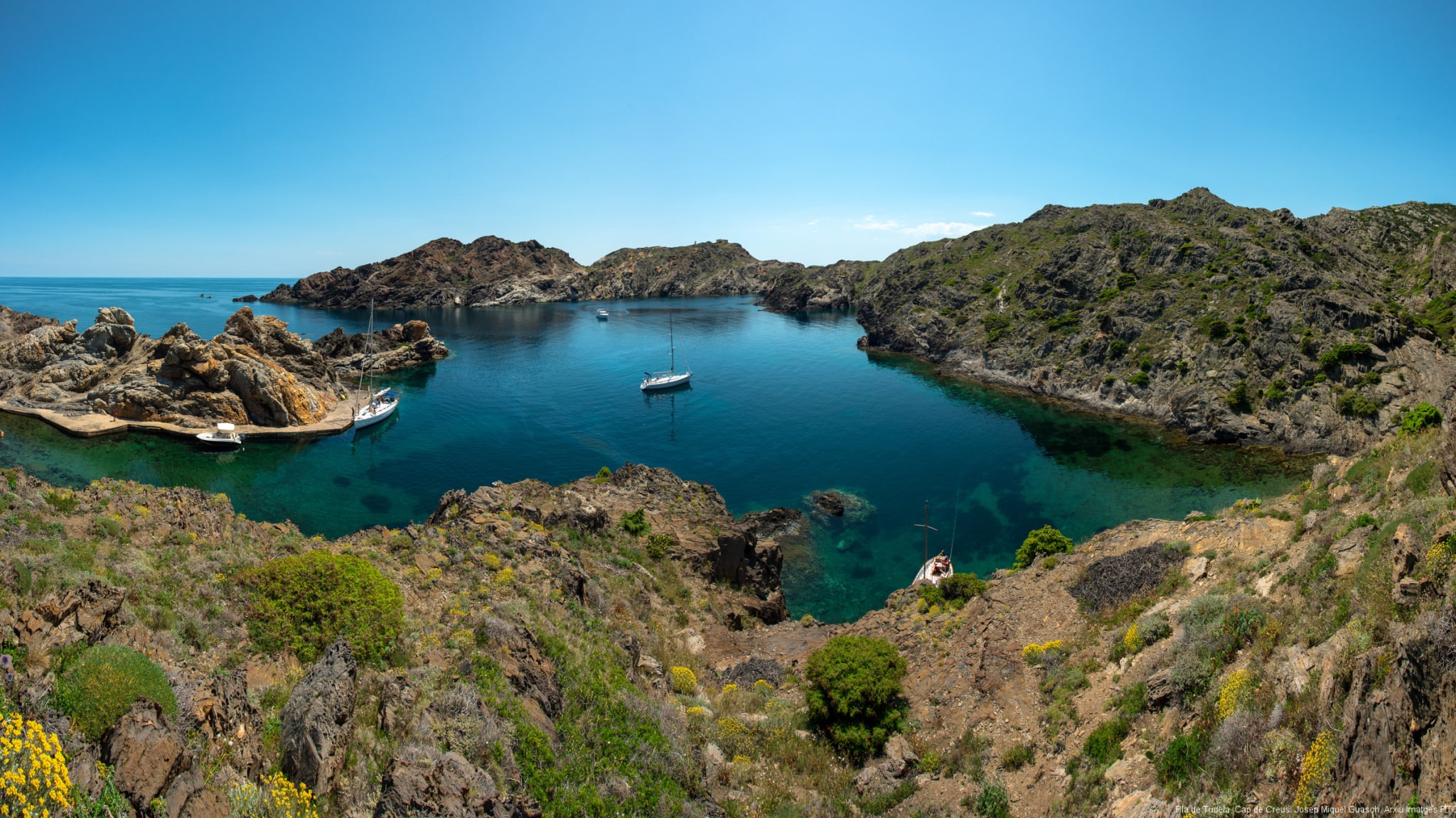 Fünf kleine Boote sind in einer Bucht vor Anker gegangen