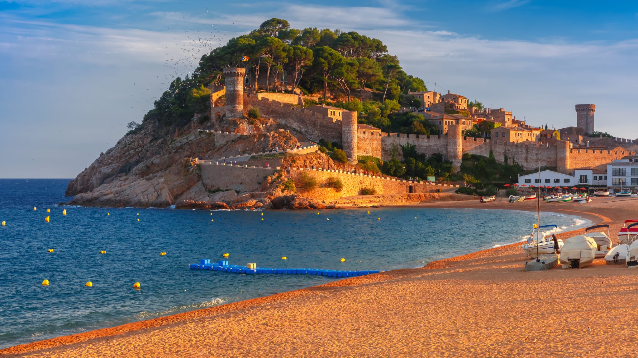 Ein Strand mit historischen Anlagen im Hintergrund