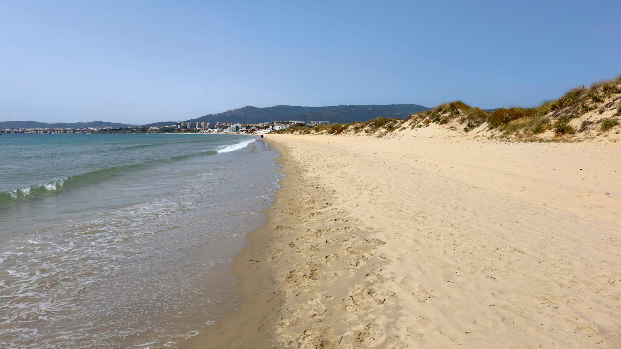 Langer Sandstrand mit kleinen Dünen