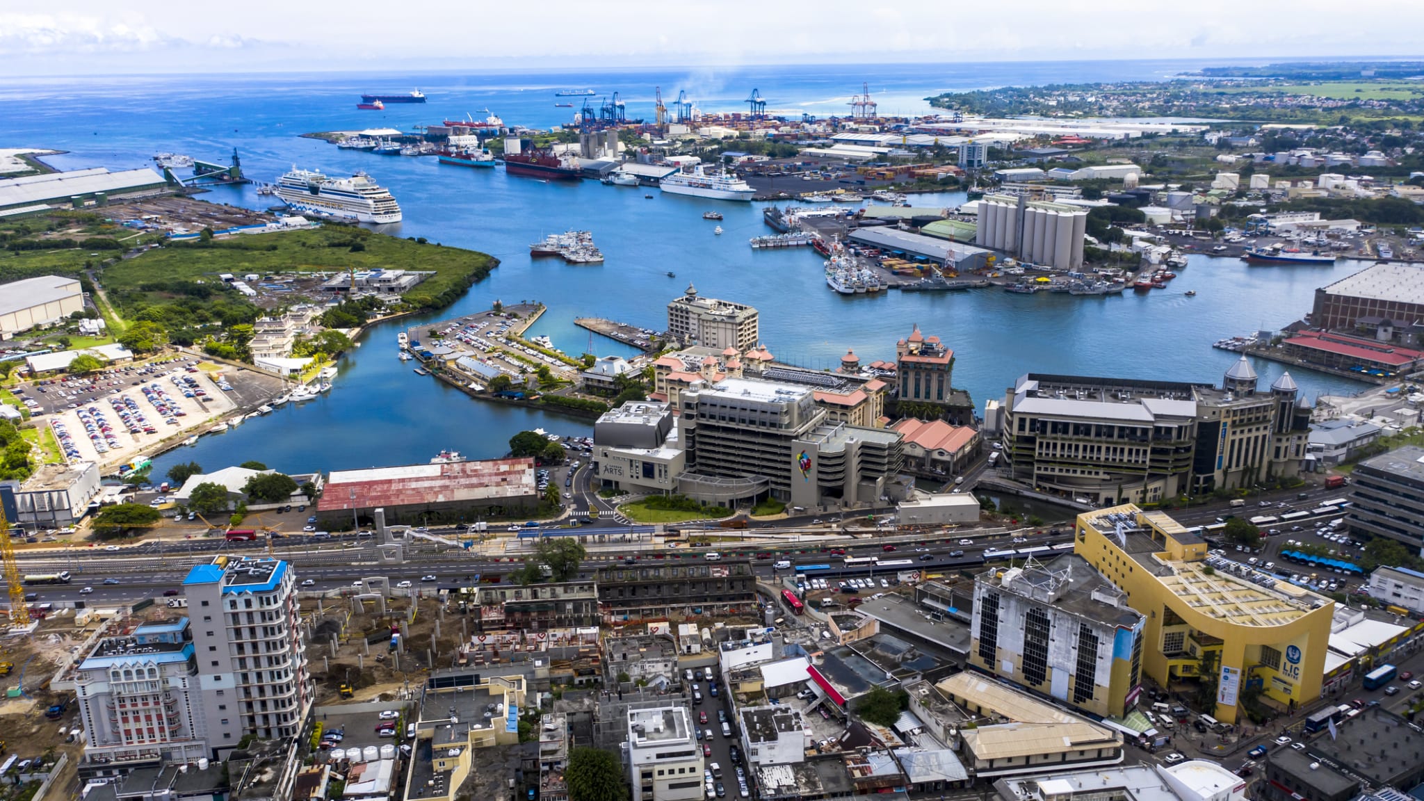 Blick auf eine Stadt am Meer mit Kreuzfahrtschiffen im Hintergrund