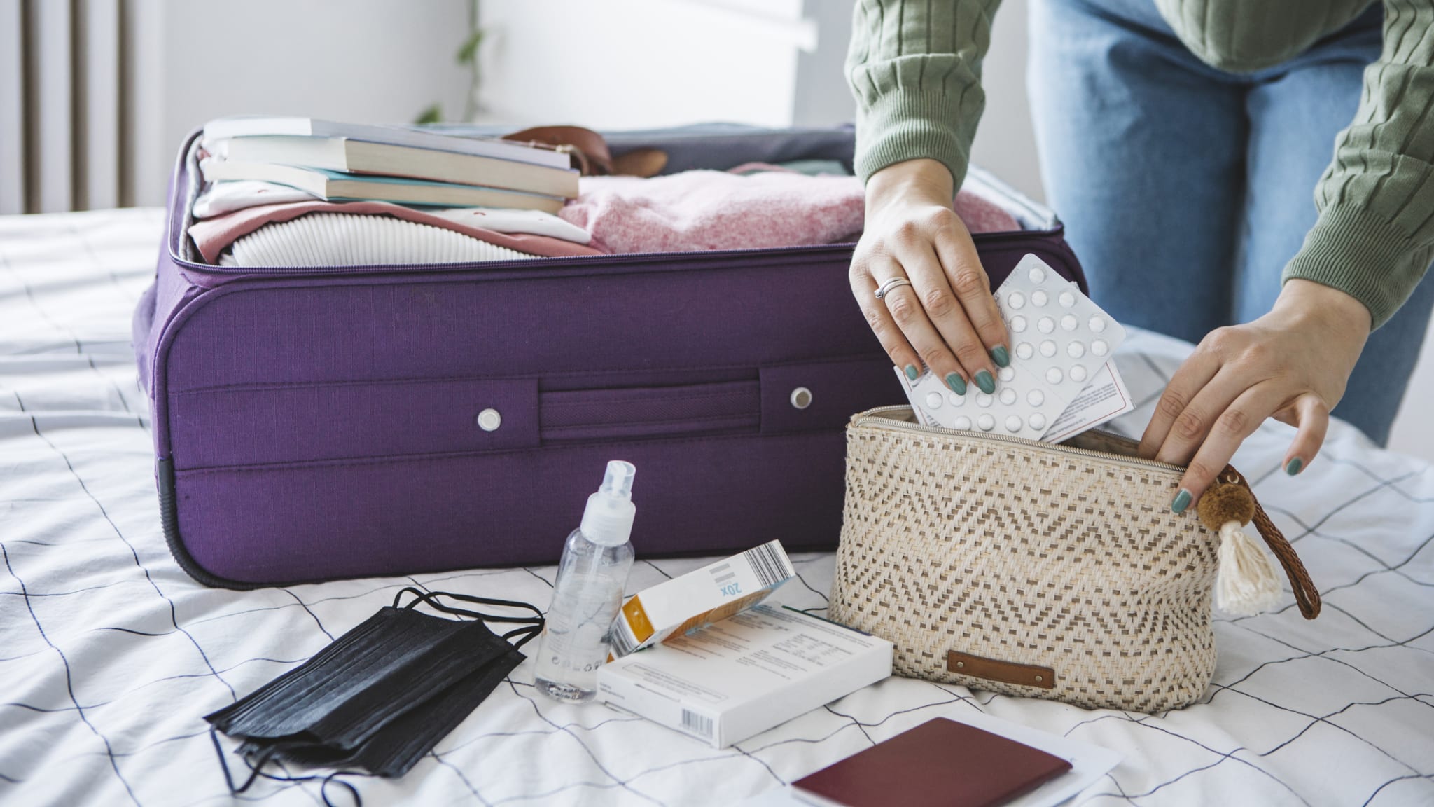 Checkliste für die Reiseapotheke: Eine Frau packt wichtige Medikamente in ihre Reiseapotheke. ©petrunjela/iStock
