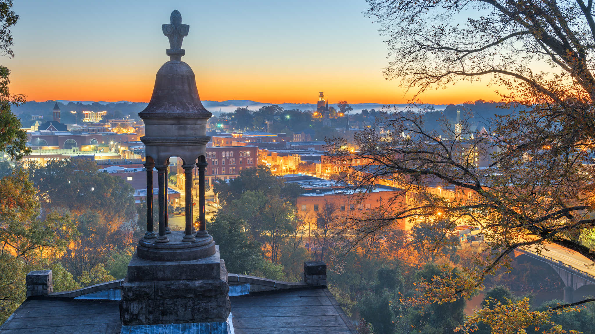 Blick von einem Hügel auf eine Stadt bei Sonnenaufgang