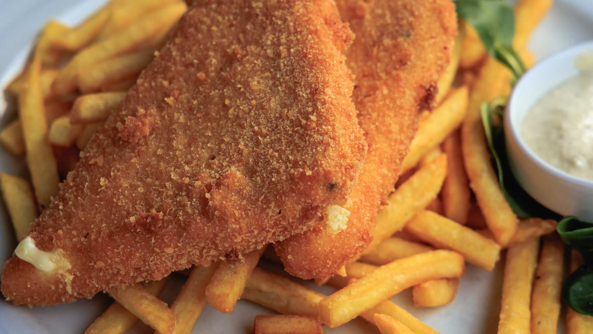 Tschechisches Gericht mit gebackenem Käse auf Pommes und Tatarsauce.