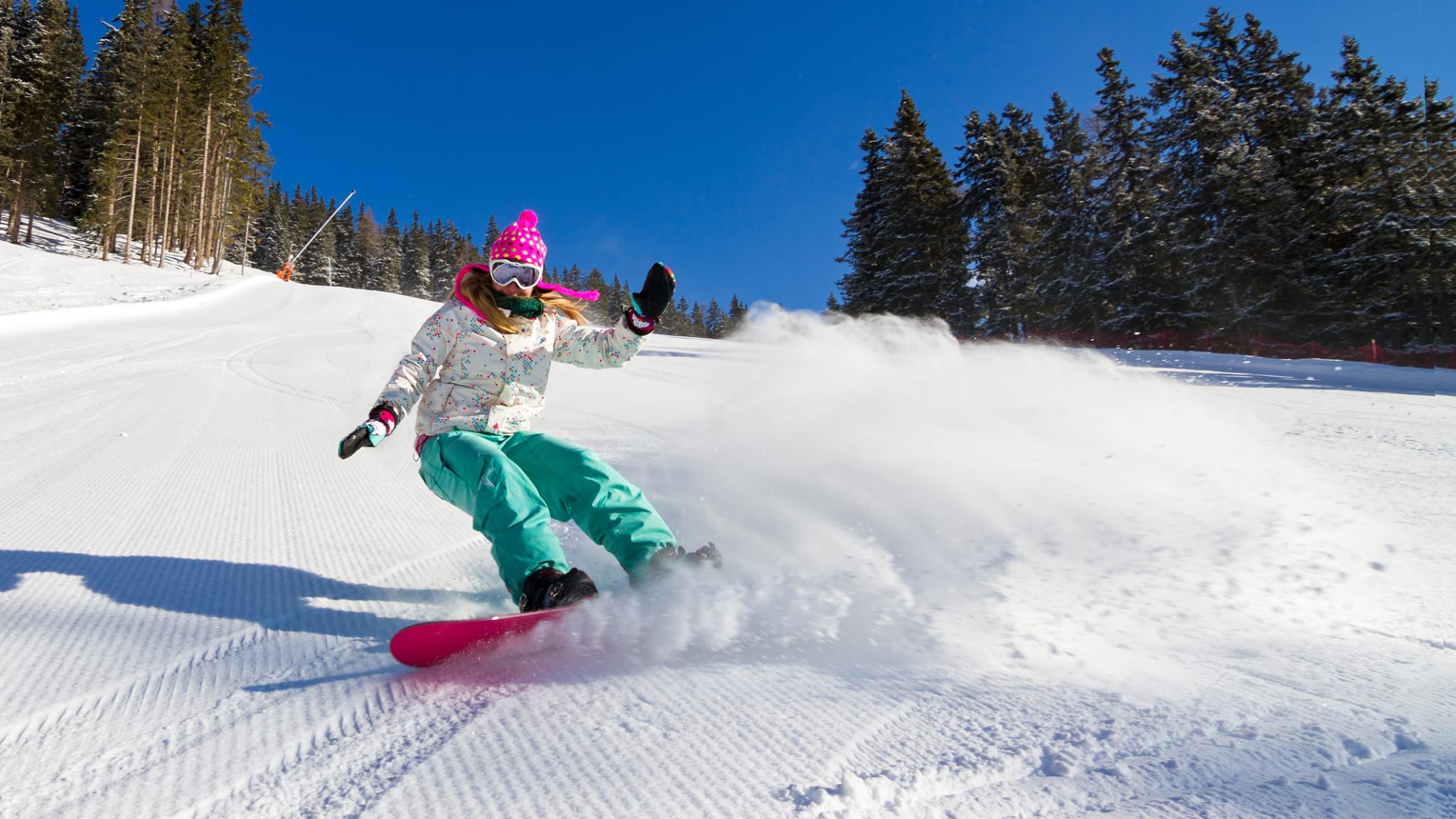 Snowboarderin auf der Piste an einem sonnigen Morgen in den italienischen Alpen © iStock.com/dennisvdw