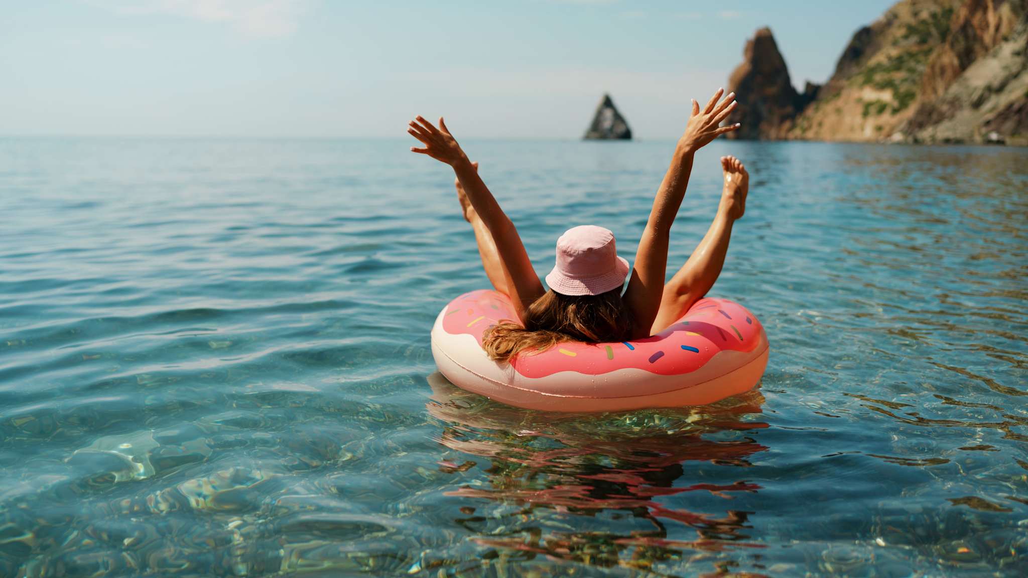 Person in aufblasbarem Donut im Meer