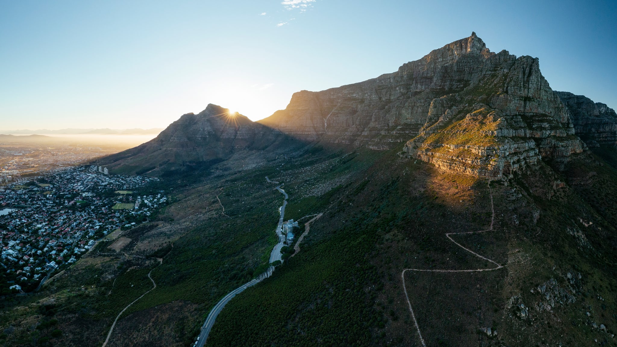 Sonne verschwindet hinter dem Tafelberg mit Kapstadt am Bildrand © Ben Pipe/HUBER IMAGES