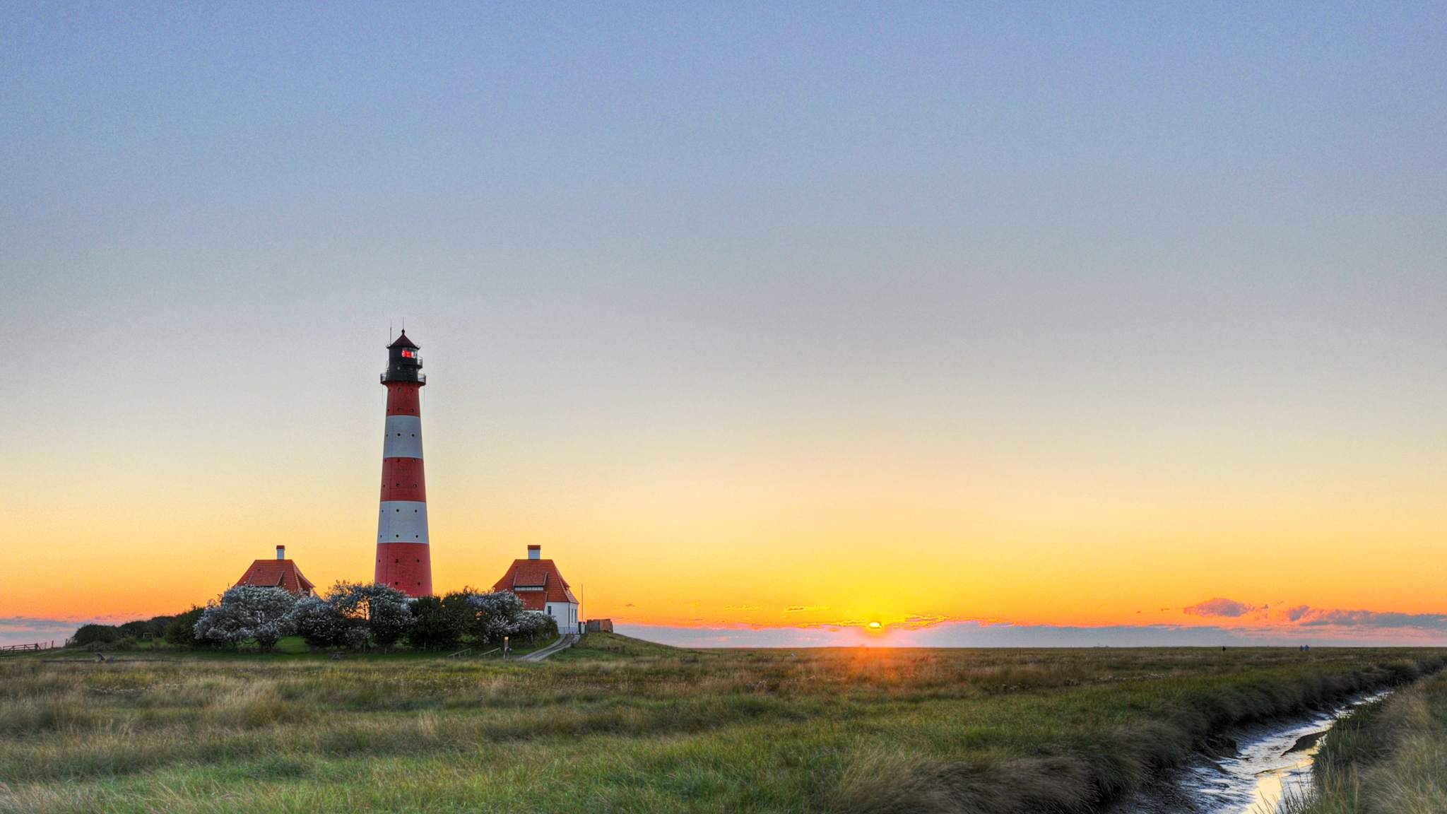 Sonnenuntergang beim Leuchtturm Westerheversand in Westerhever auf der Halbinsel Eiderstedt in Schleswig-Holstein.