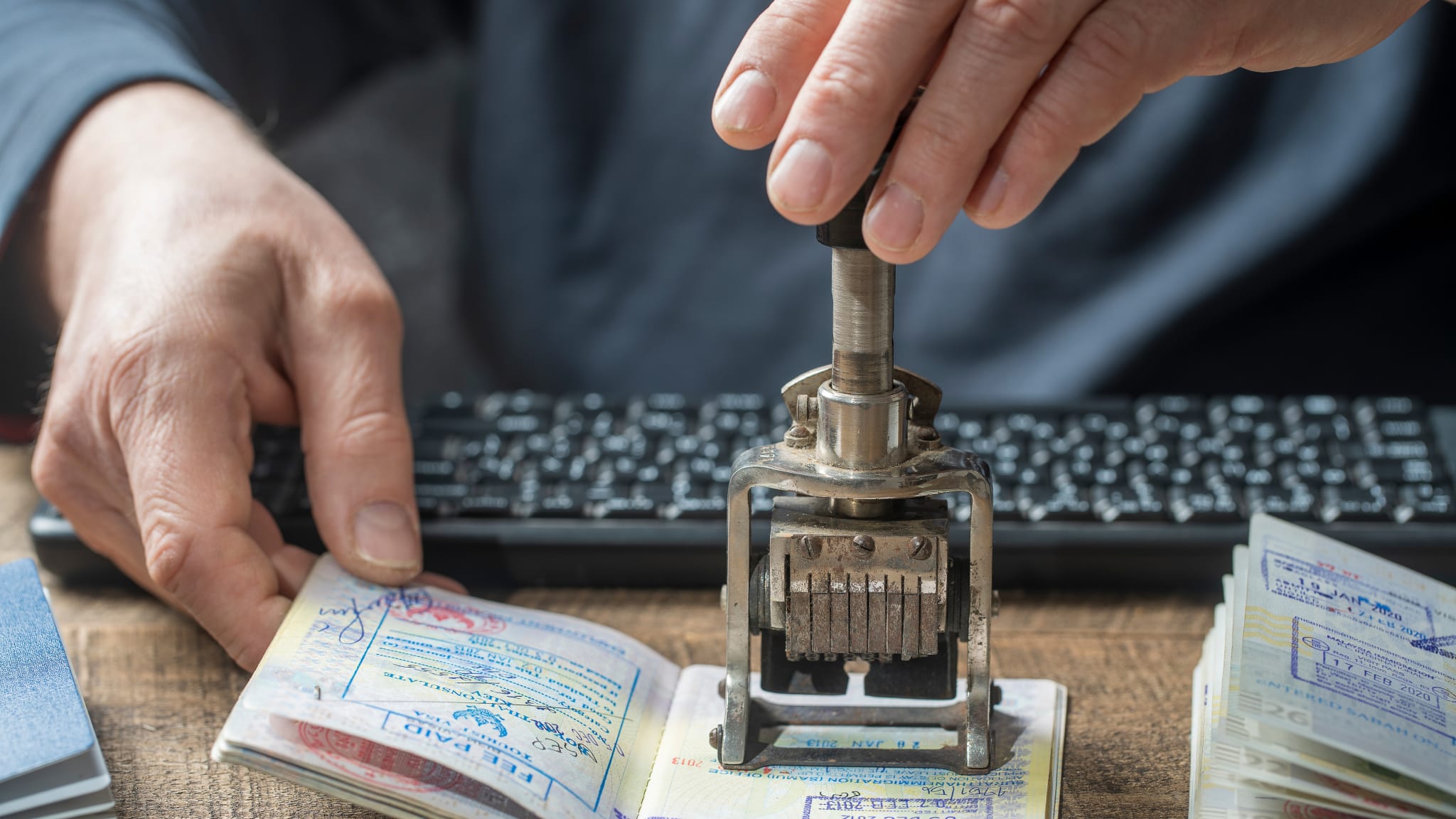 Ein Reisepass wird gestempelt © OlegD - stock.adobe.com