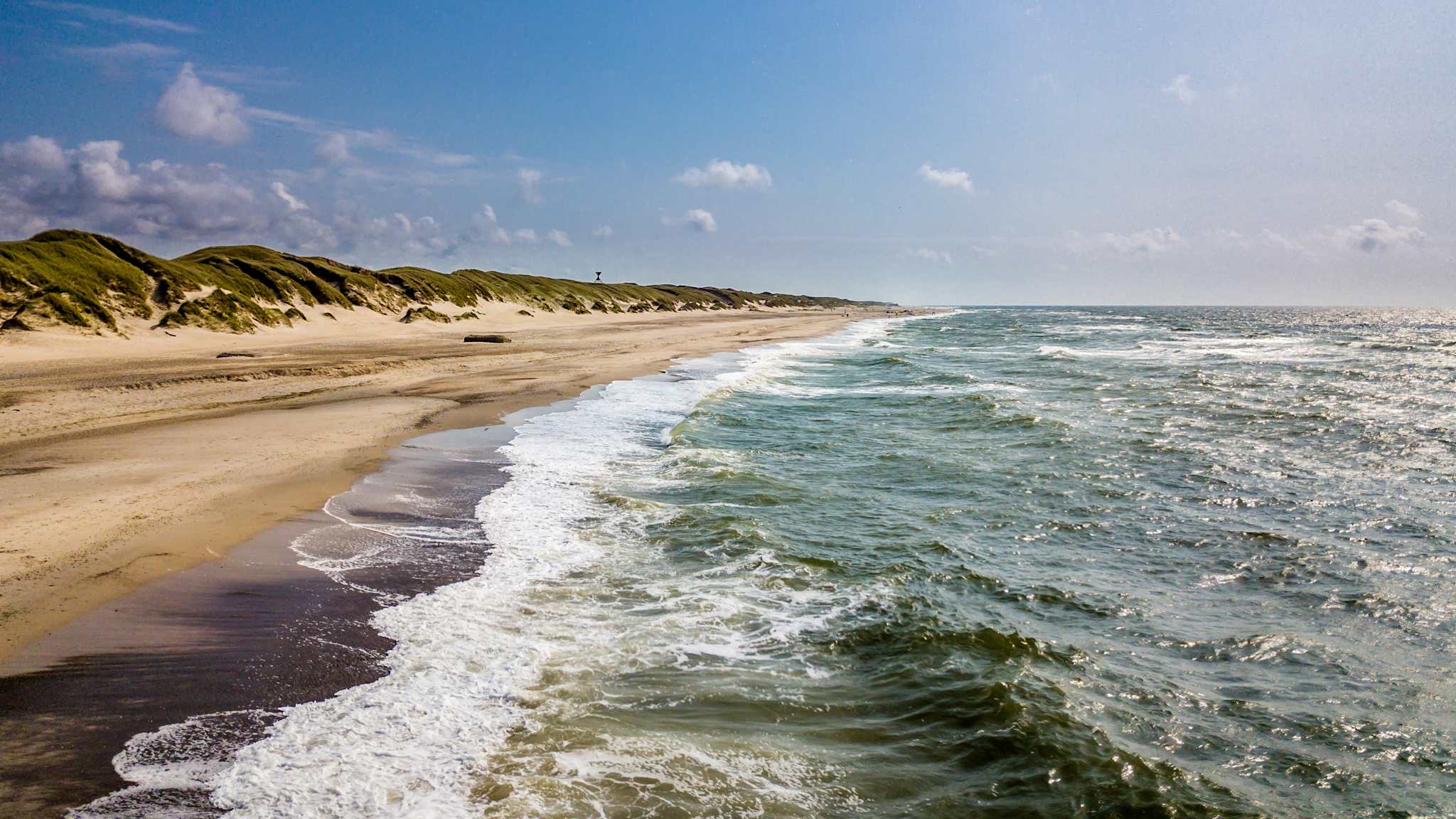 Langer Sandstrand mit Dünen am Meer