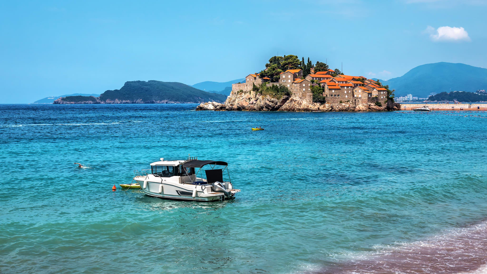 Touristenboot im Meer in der Nähe des Ferienortes Sveti Stefan ©iStock.com/vovashevchuk