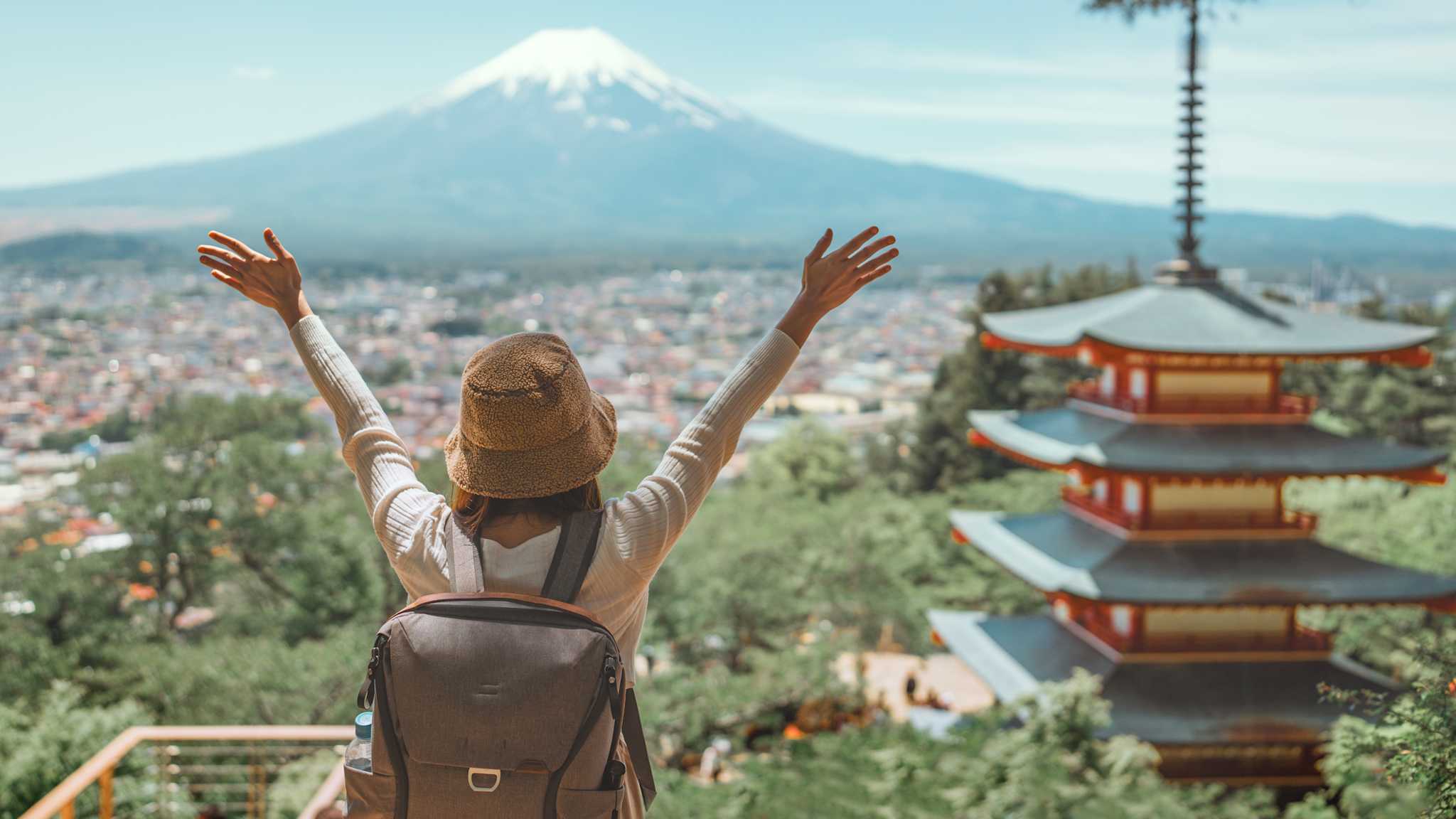 Touristin mit ausgestreckten Armen vor Berg in Japan