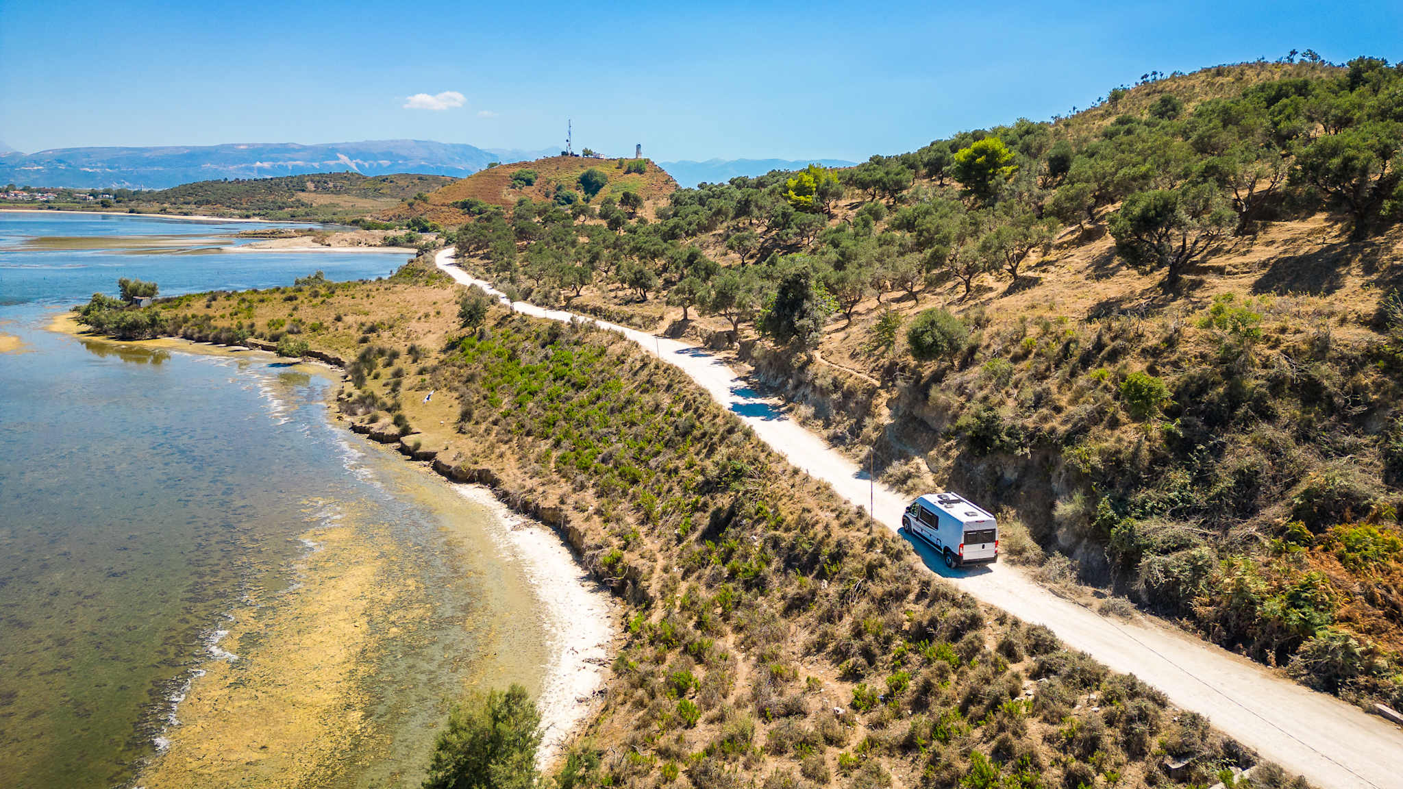 Campervan fährt auf einer Straße am Meer