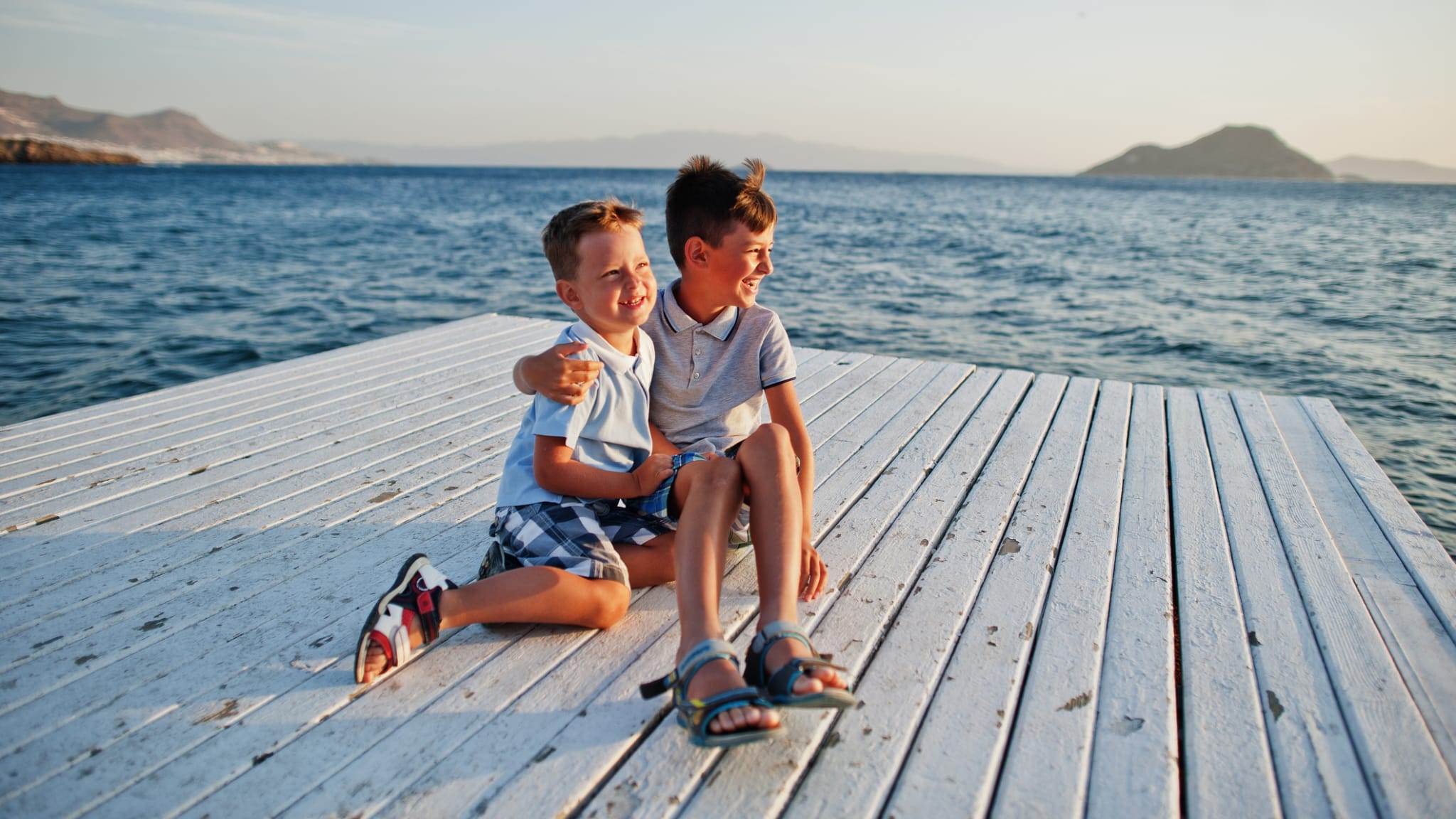 Zwei Brüder sitzen im Türkei Resort am Pier am Mittelmeer ©iStock.com/ASphotowed