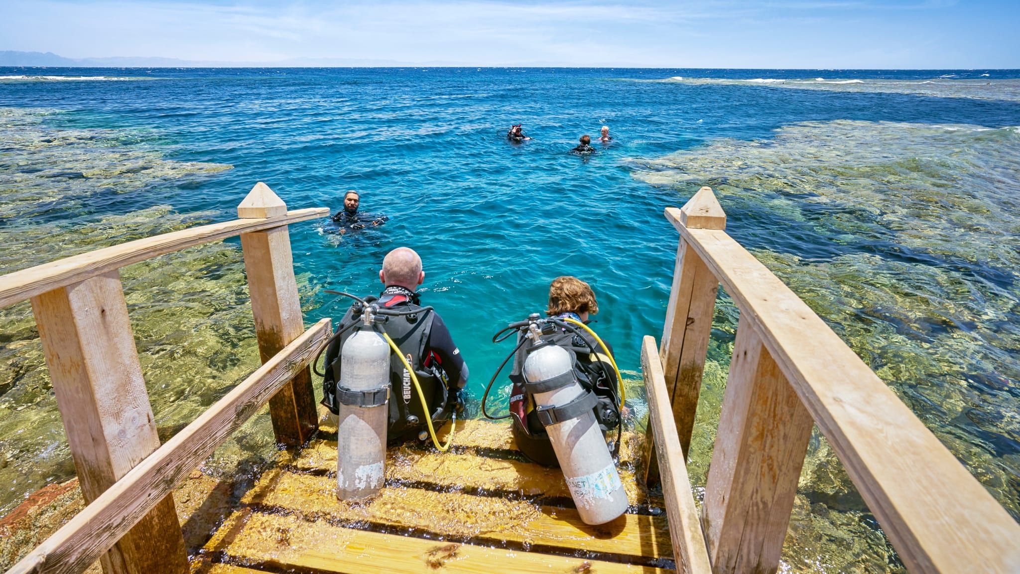 Zwei Taucher sitzen auf einem Steg bereit ins Wasser zu gehen © Jan Wlodarczyk/HUBER IMAGES
