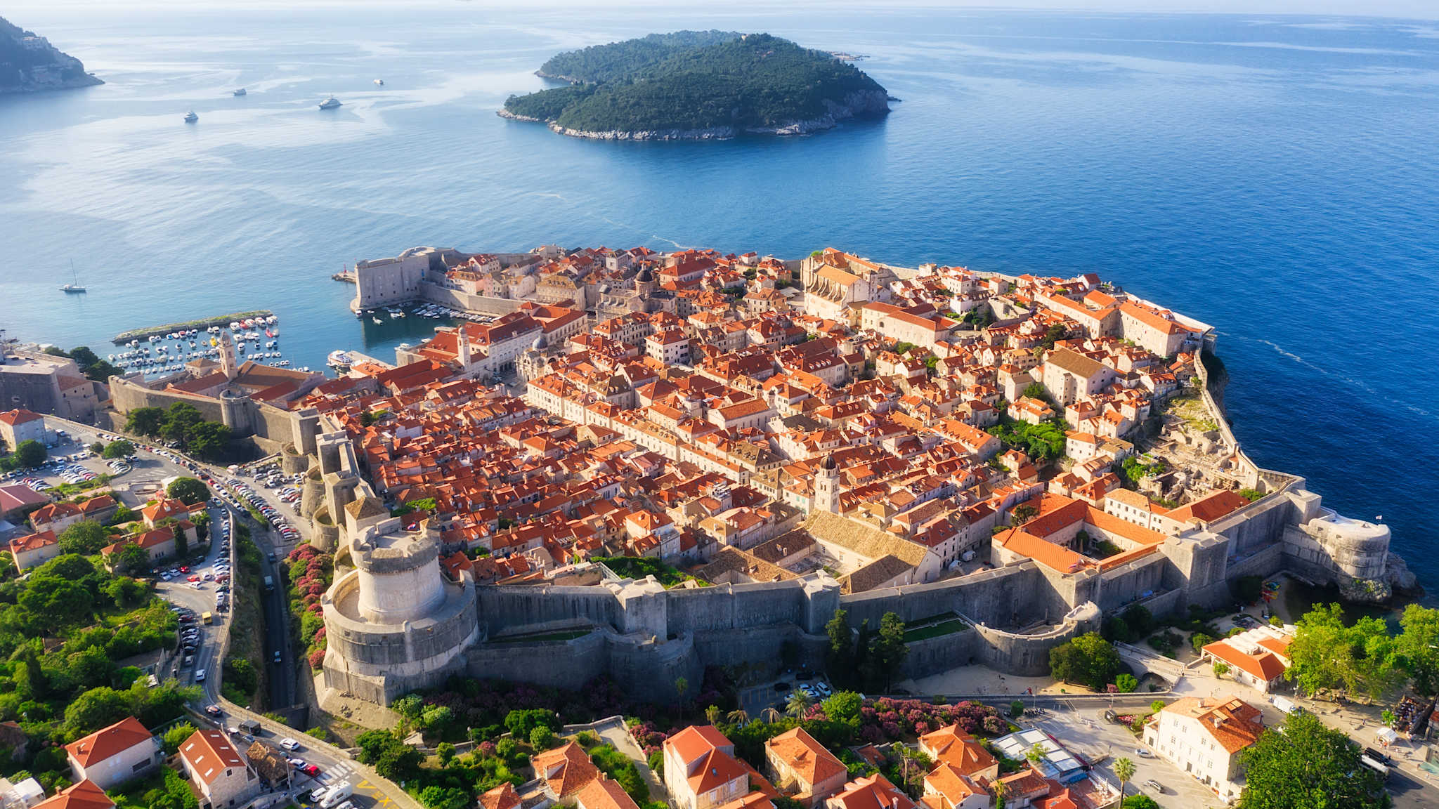 Draufsicht auf eine Altstadt am Meer mit einer großen Stadtmauer.