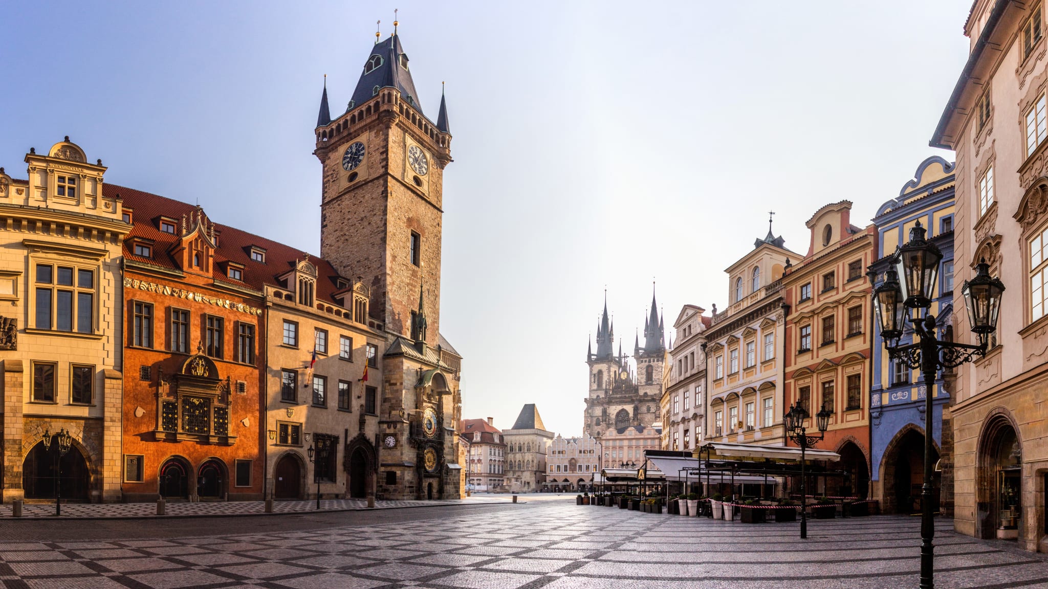 Ein Platz mit alten Gebäuden und einem viereckigen, mittelalterlichen Turm mit einer Uhr