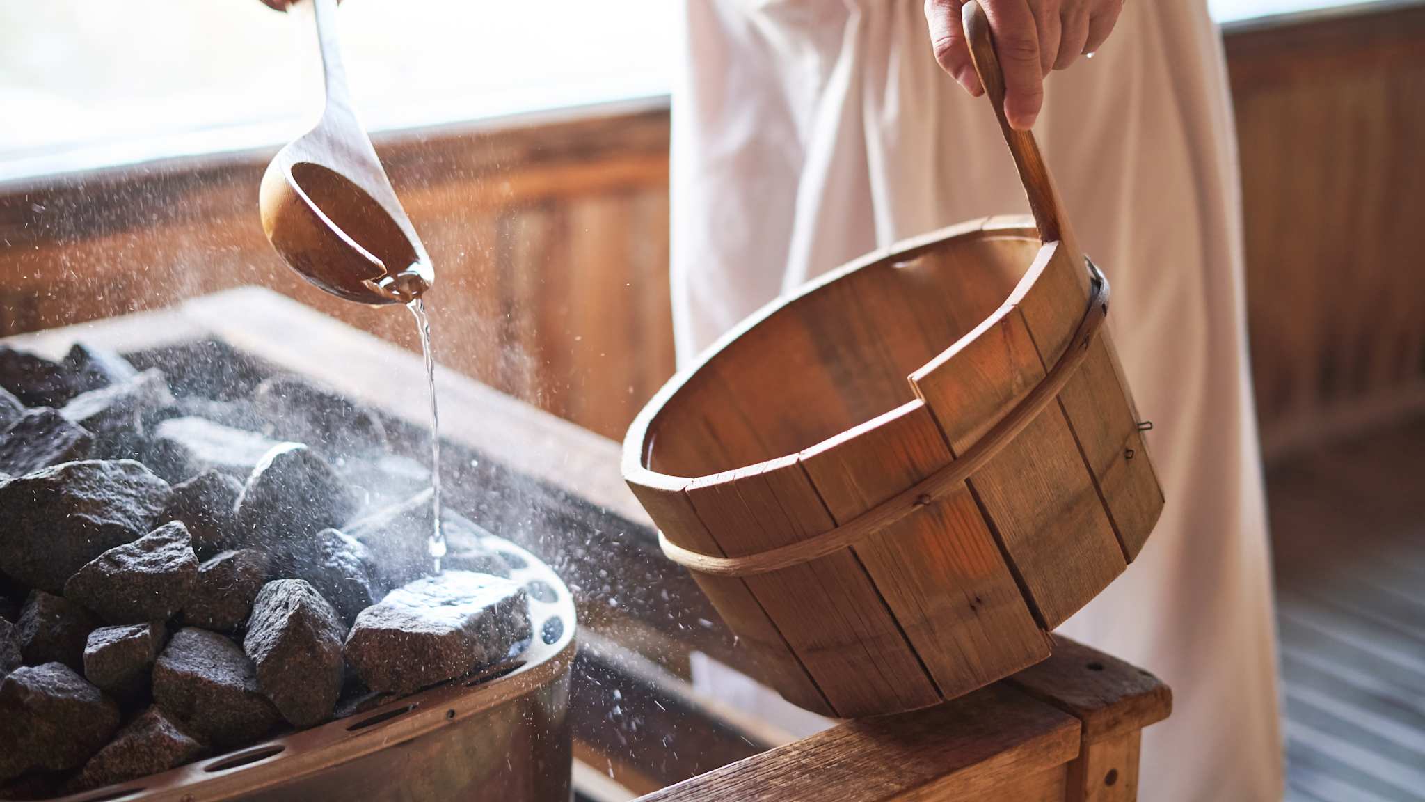 Ein Mann macht einen Aufguss in einer Sauna