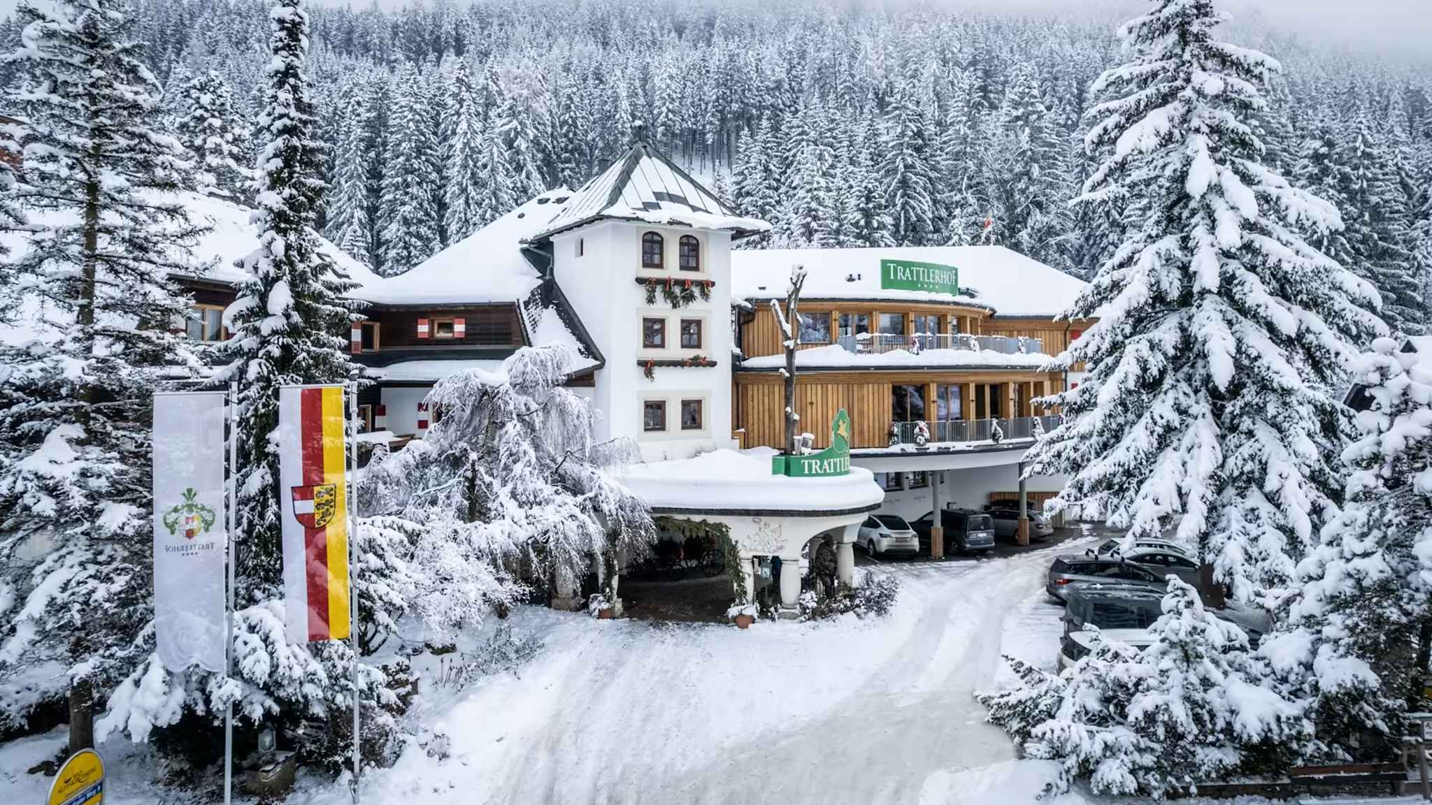 Außenanlage eines Hotels im Schnee, das umgeben ist von Nadelbäumen