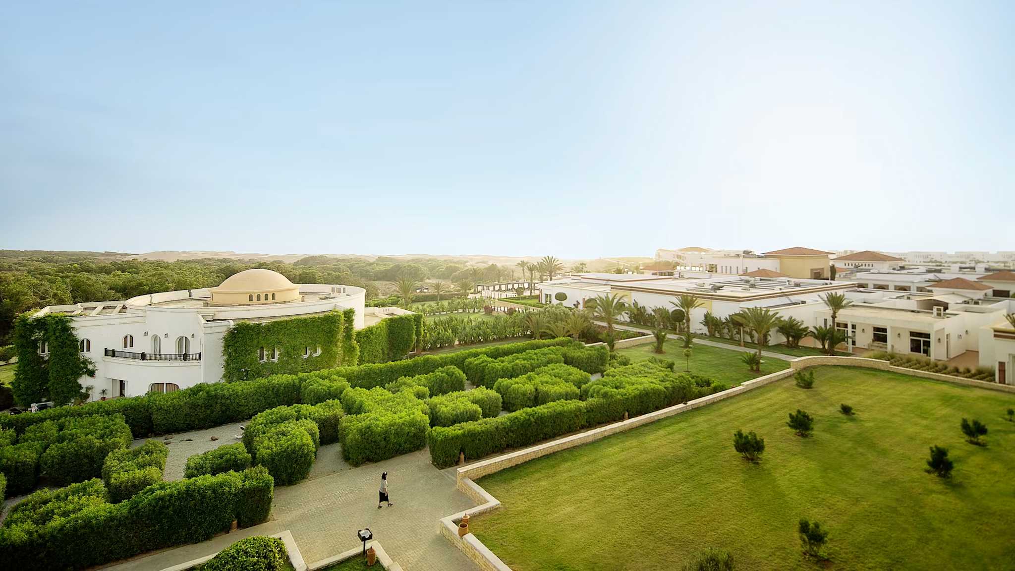 Die Anlage eines Hotels mit gepflegten Grünanlagen und weißen Bungalows