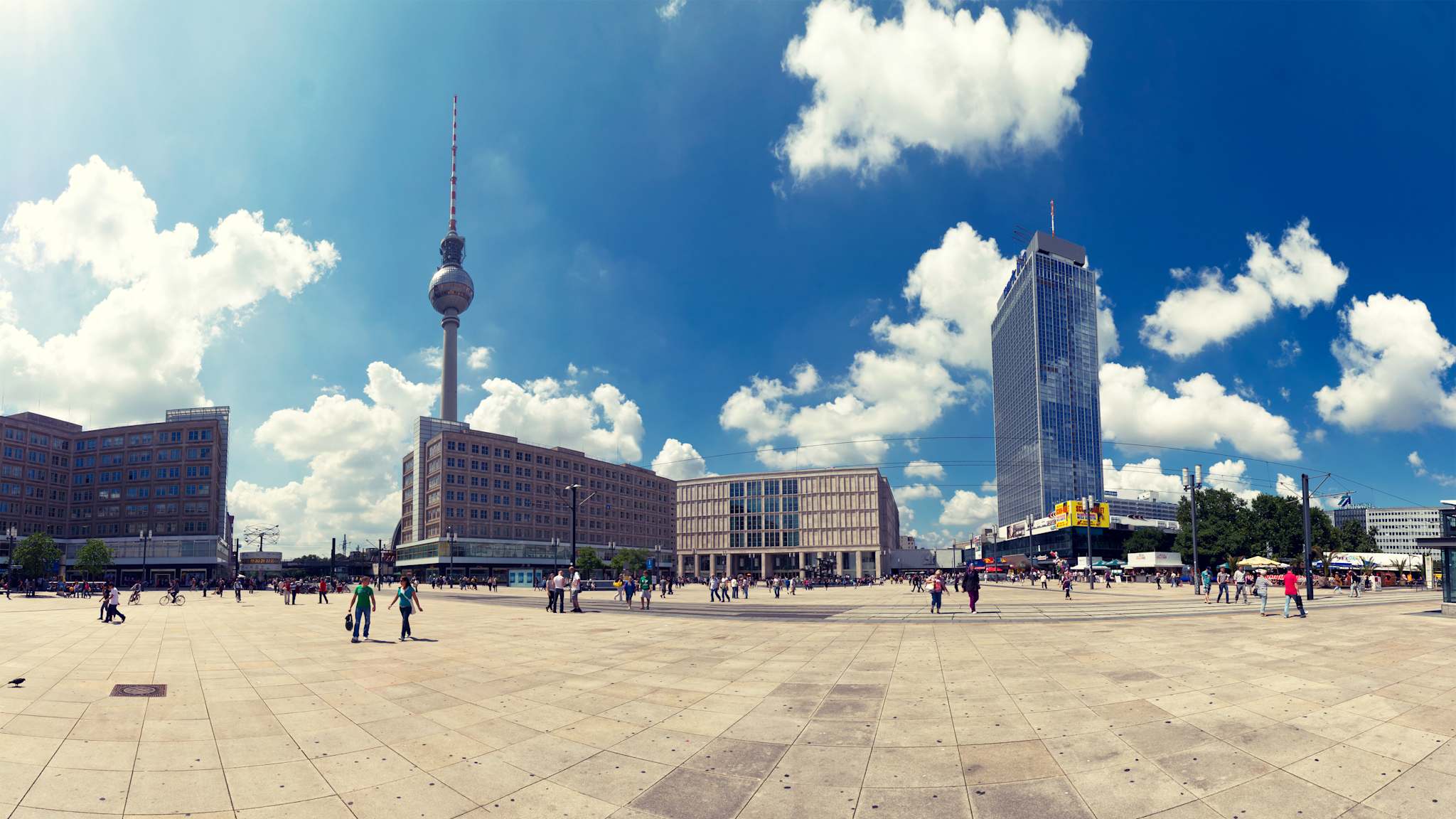 Ein weiter Platz mit einem Fernsehturm und einige Menschen.