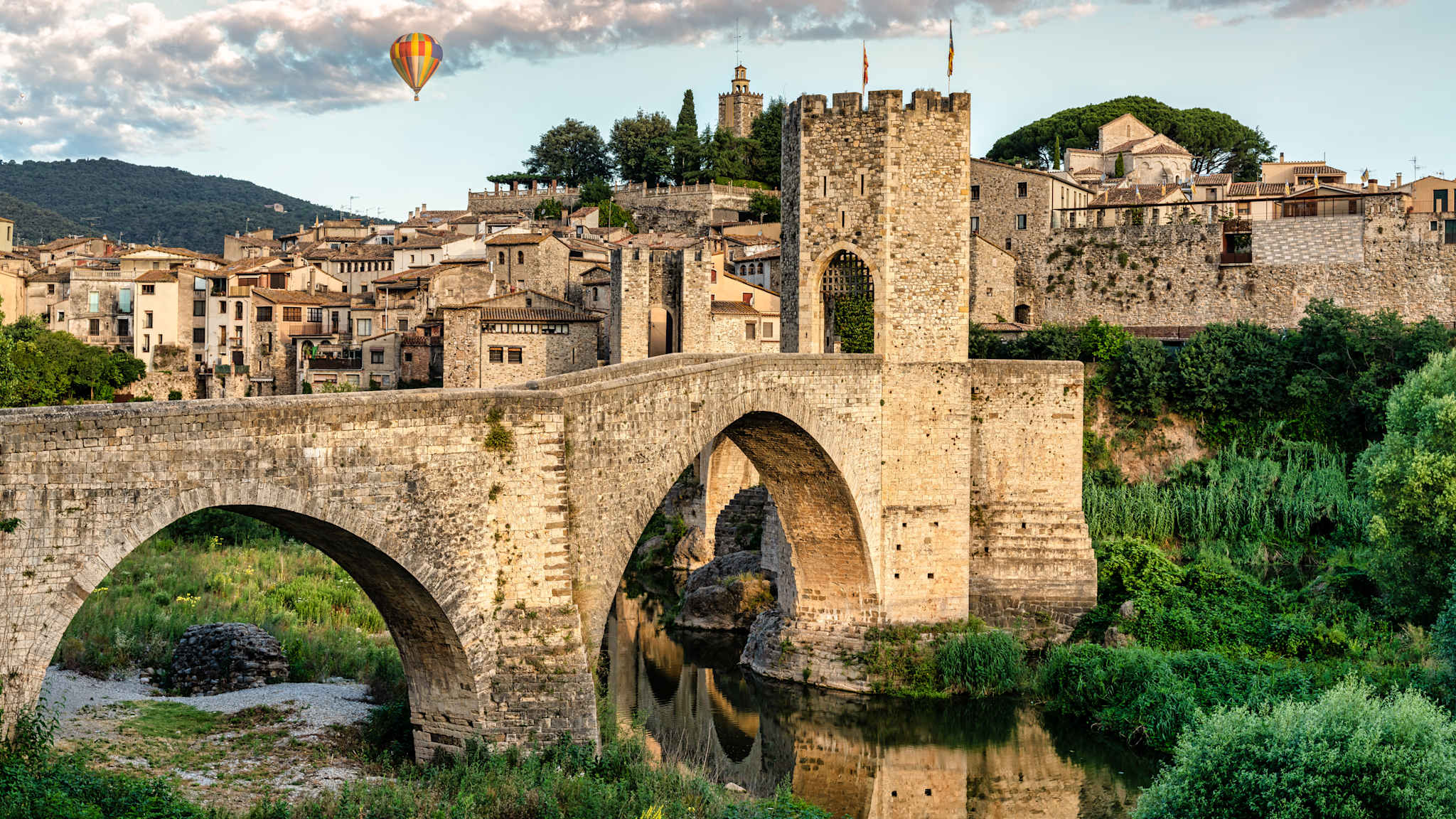 Ein Heißluftballon fährt über das mittelalterliche Dorf Besalú hinweg