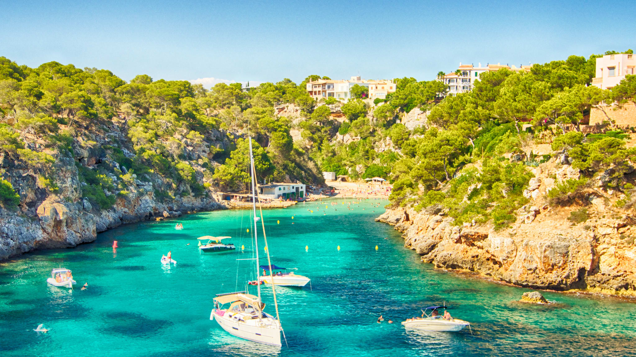 blaues Meer in einer Bucht von Mallorca mit einigen Booten © iStock.com/Josep Bernat Sànchez Moner