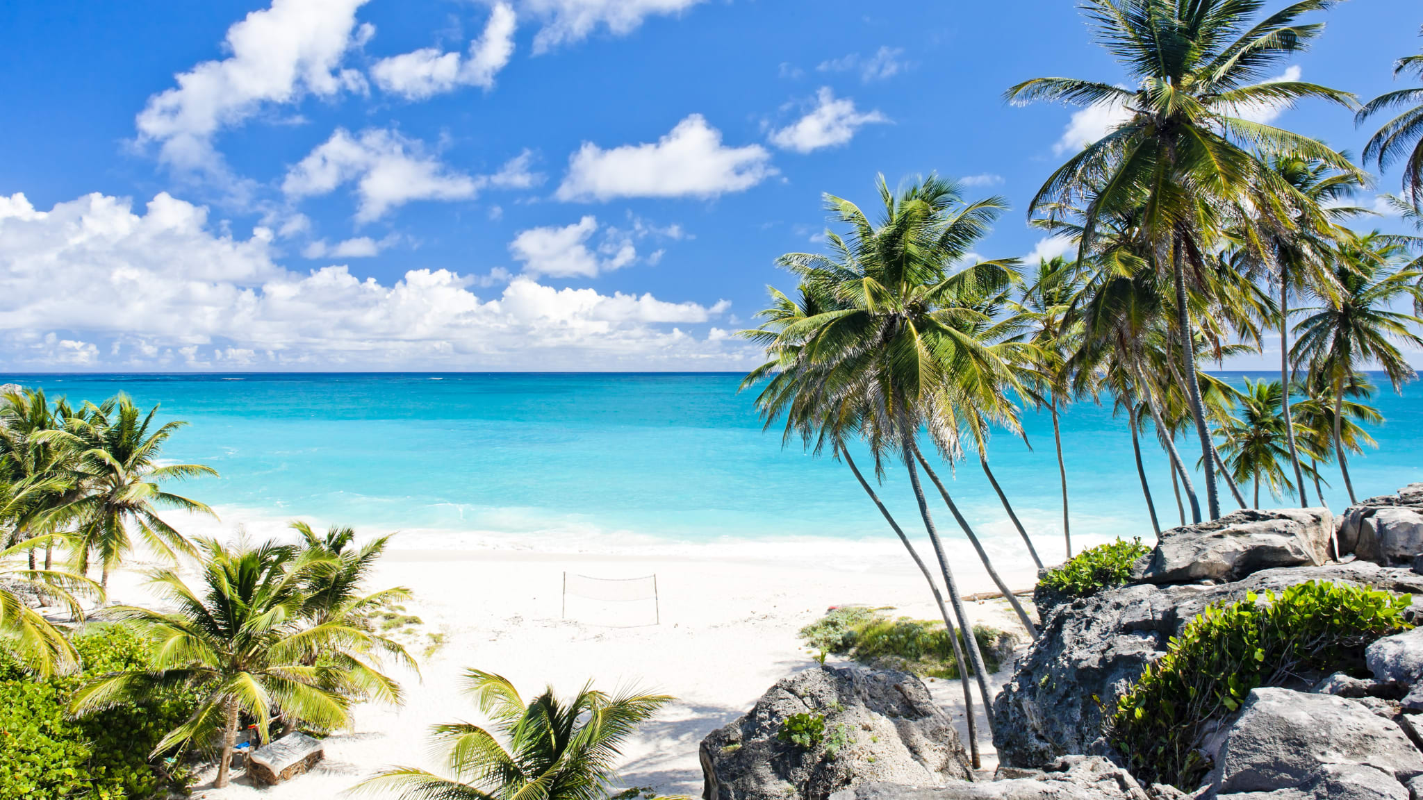 Blick auf den Strand Bottom Bay mit Palmen rechts, weißem Sand und azurblauem Meer