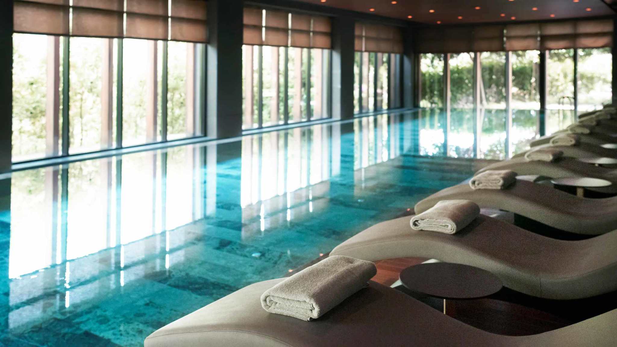 Ein Indoorpool mit gemütlichen Liegen.