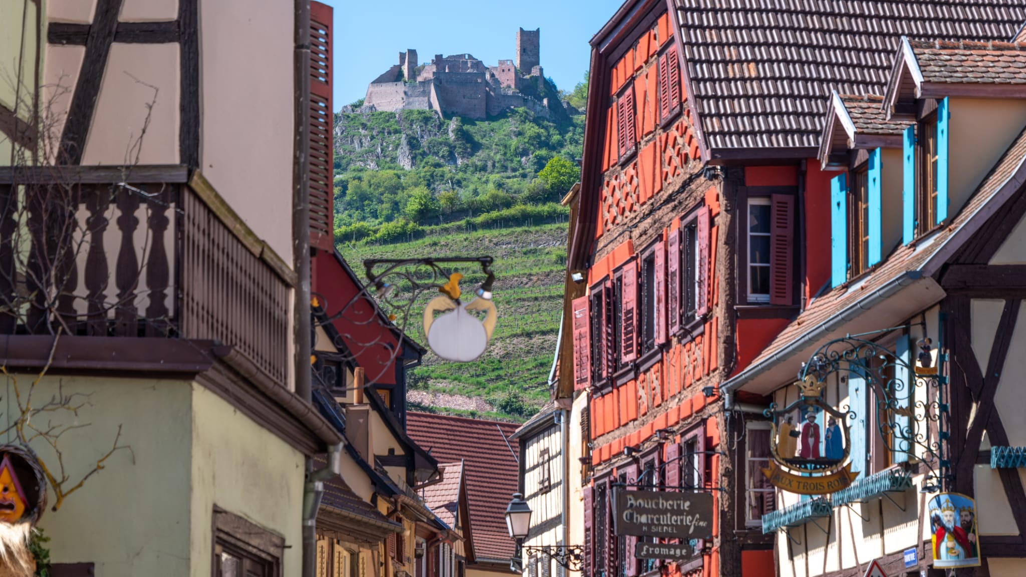 Blick durch Häusergassen auf das Schloss von Ribeauvillé, Frankreich.