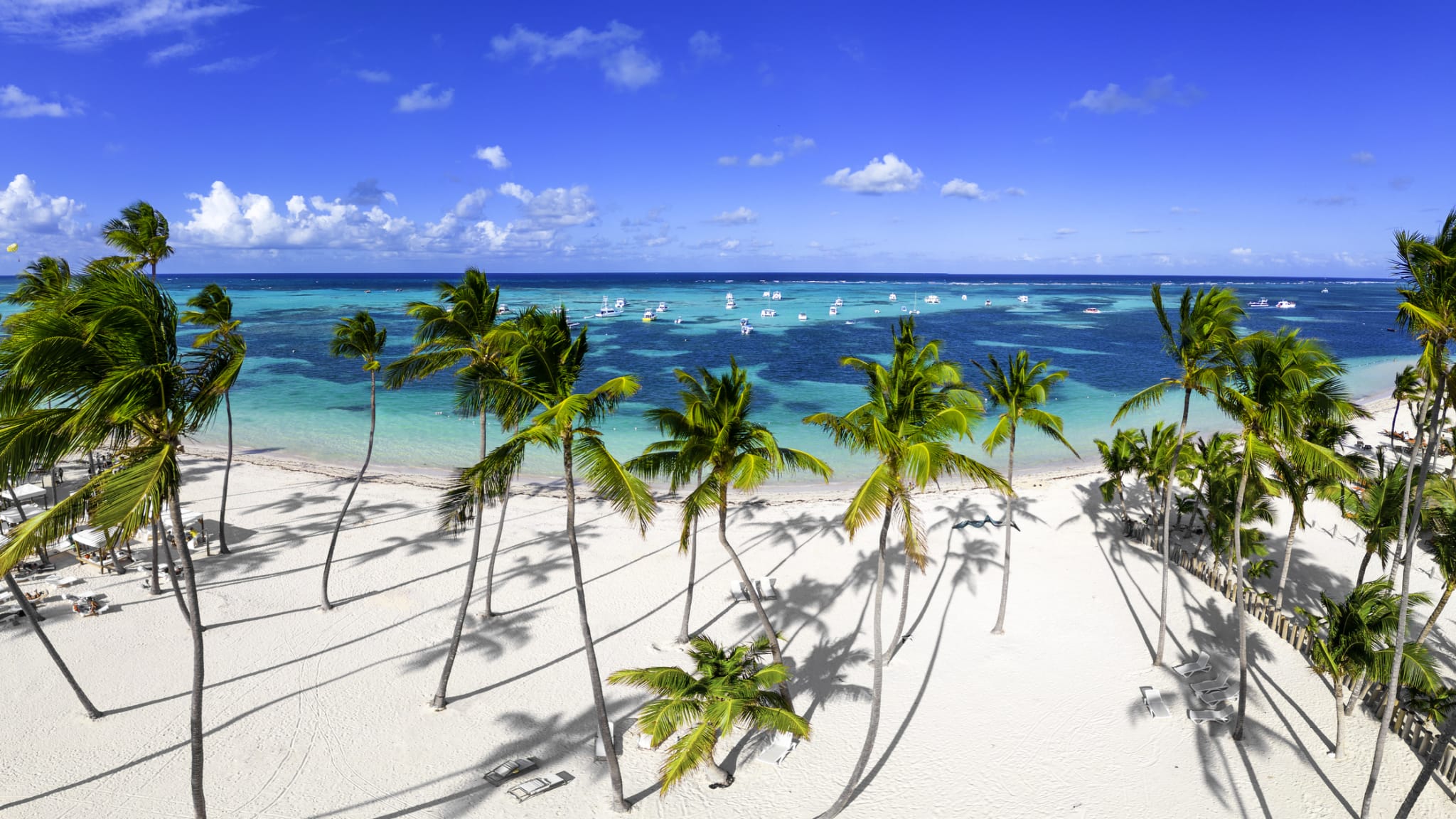 Boote im Meer und Palmen am Bavaro-Strand, Dominikanische Republik.