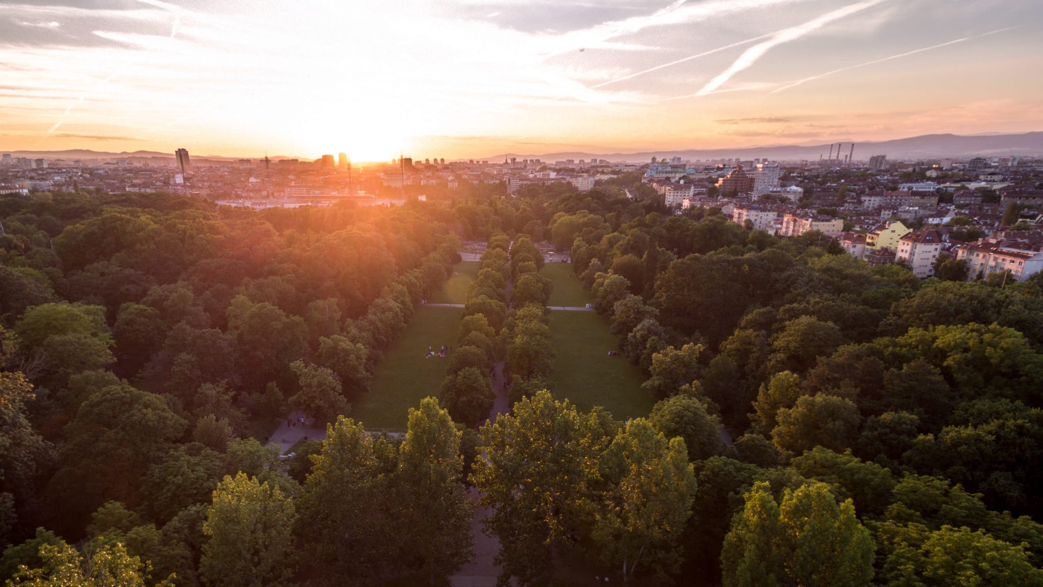 Blick auf einen weitläufigen Park bei Sonnenuntergang