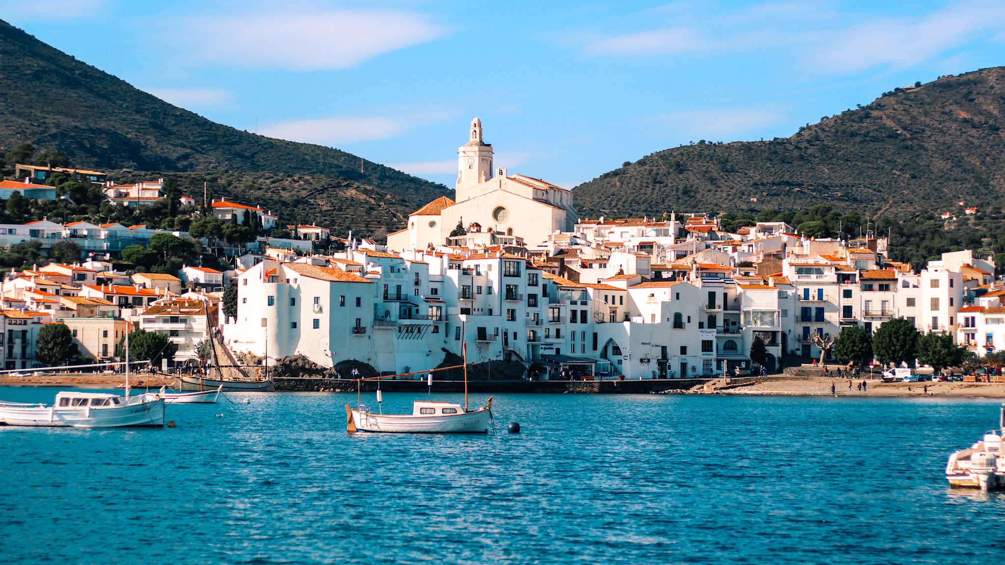 Blick vom Meer auf eine weiße Stadt mit einer Kirche.