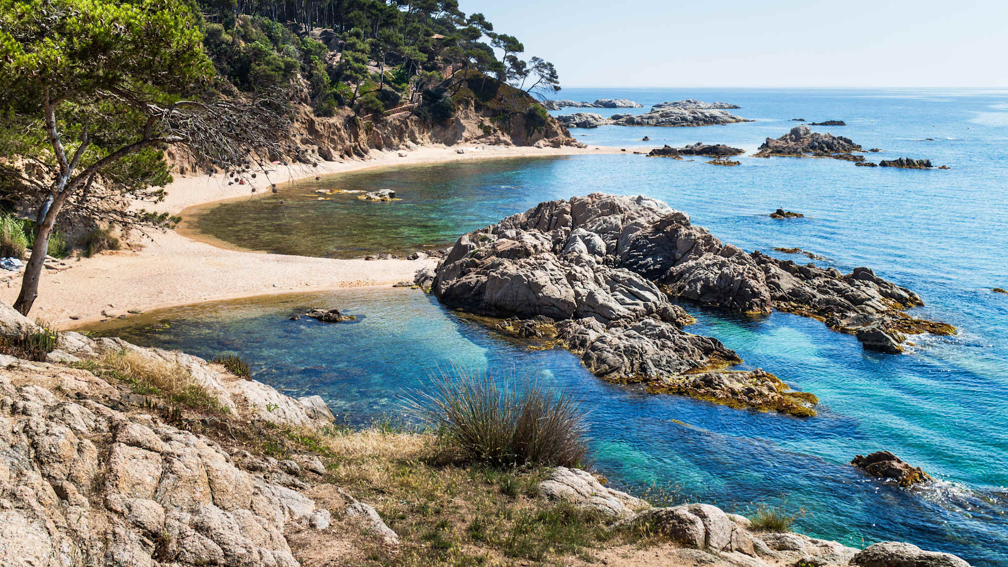 Eine Doppelbucht mit Felsen und Strand.