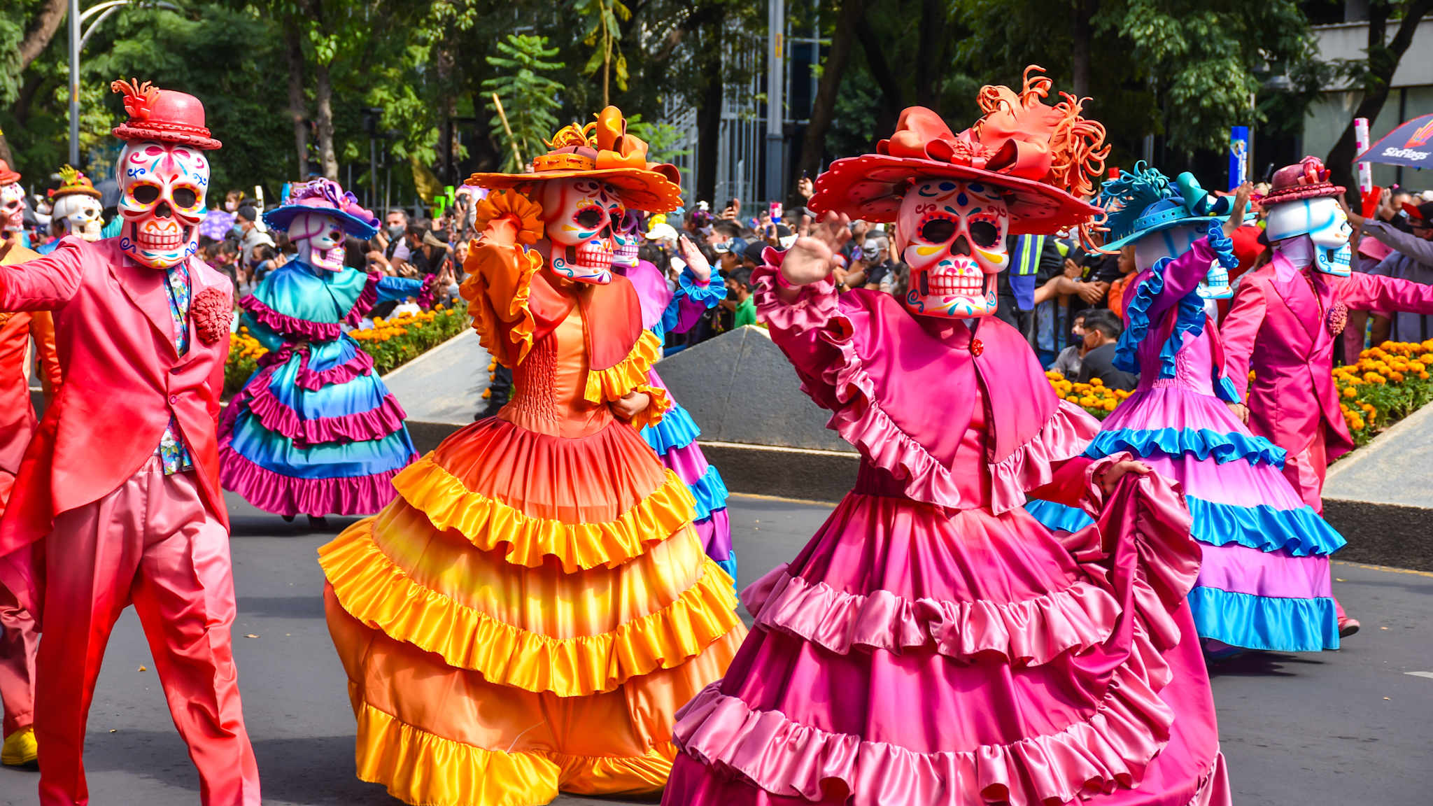 Personen in bunten Kostümen und Totenkopfmasken