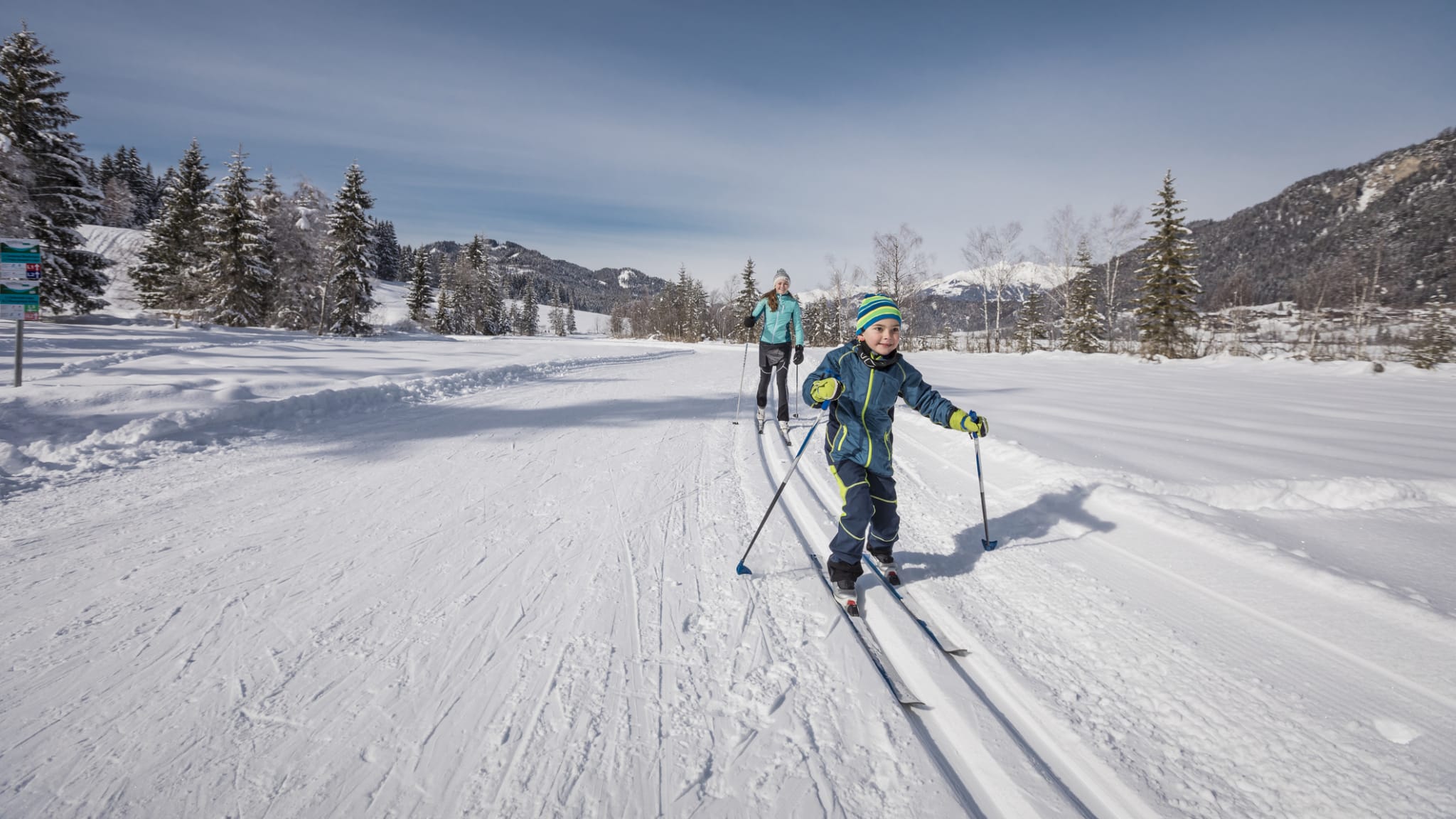 Ein Kind fährt gemeinsam mit der Mutter Ski in Kärnten, Österreich.