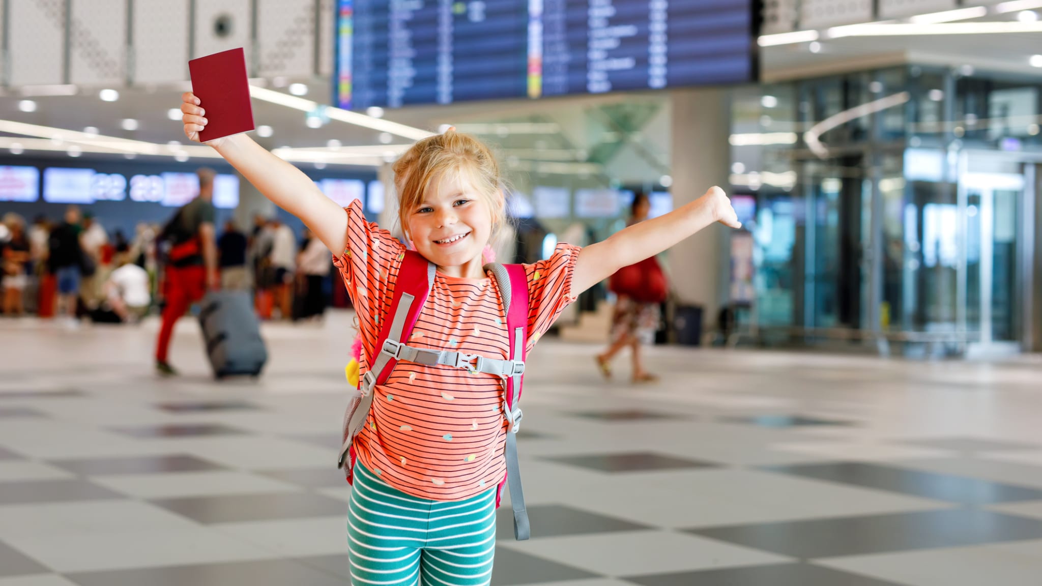 Ein kleines Mädchen mit ihrem Reisepass am Flughafen. © romrodinka/iStock / Getty Images Plus via Getty Images