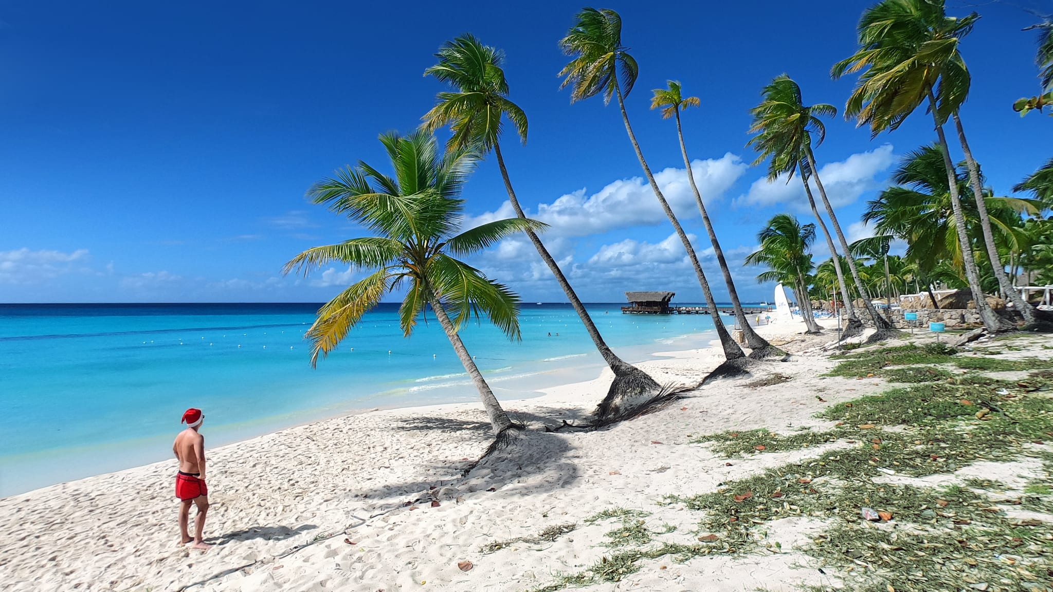 Ein Mann mit Weihnachtsmütze an einem Strand in der Dominikanischen Republik.