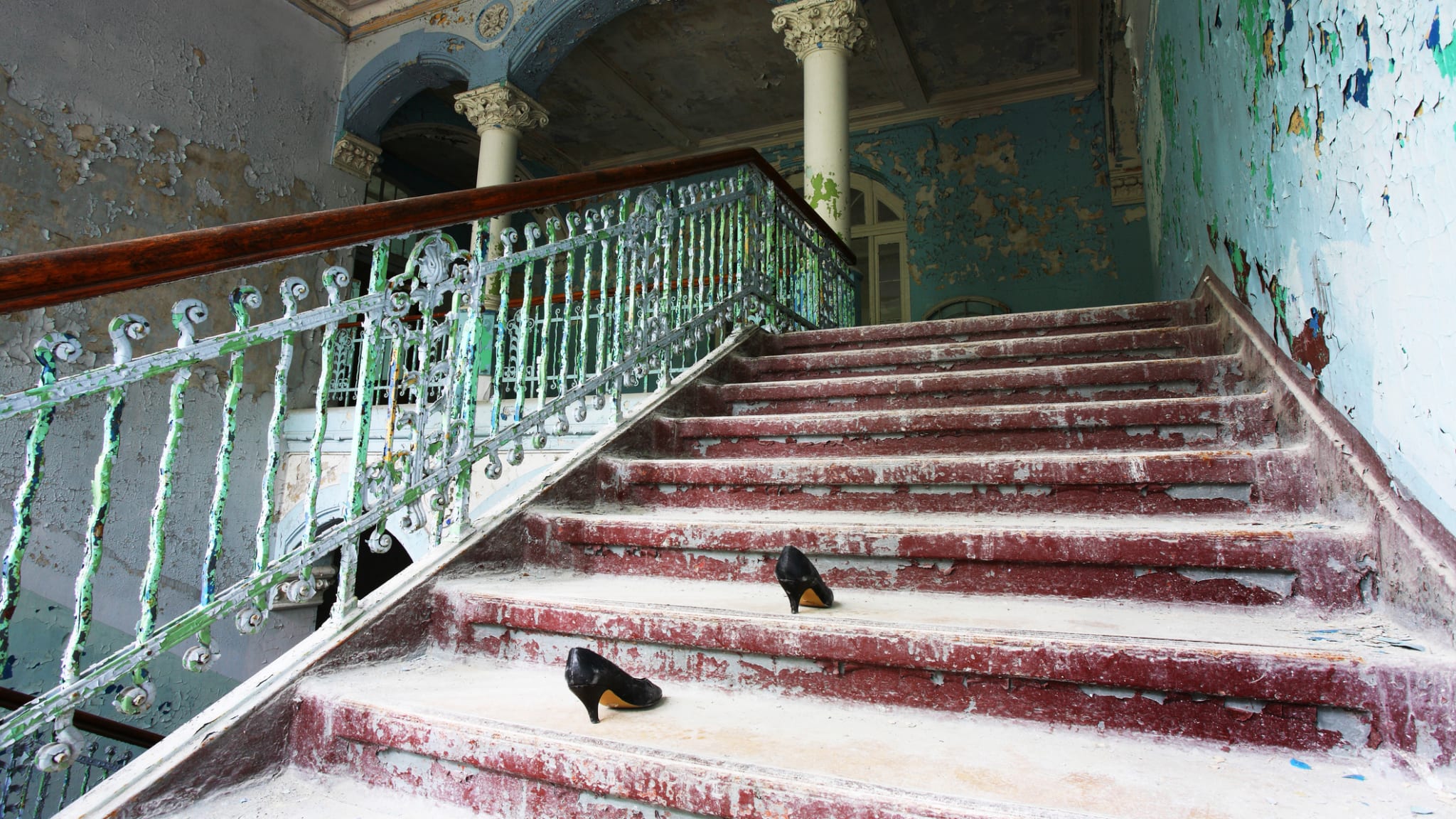 Ein Paar Frauenschuhe auf der Treppe eines heruntergekommenen Hauses.