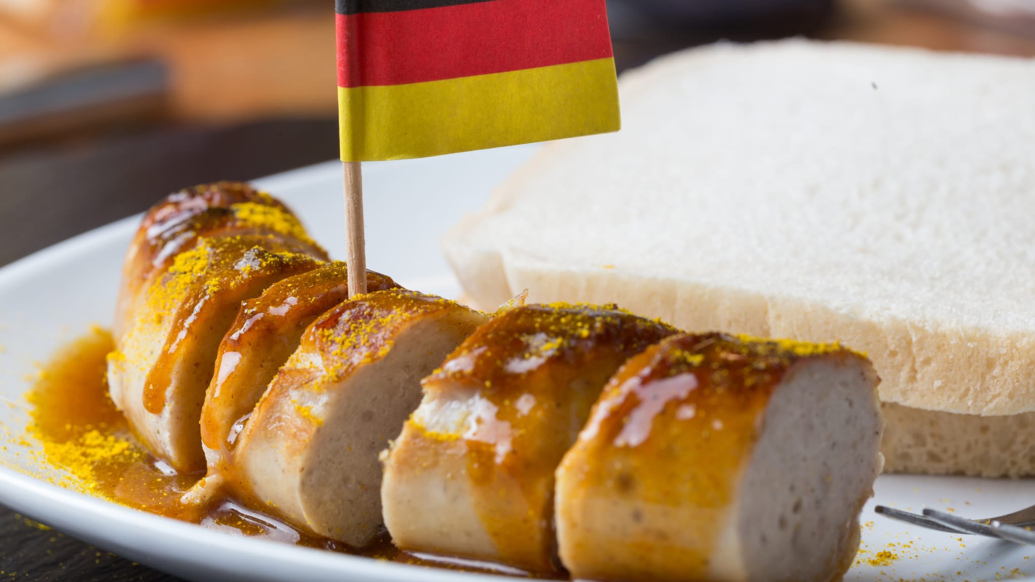 Eine Currywurst mit einer deutschen Flagge © Teka77/iStock / Getty Images Plus via Getty Images