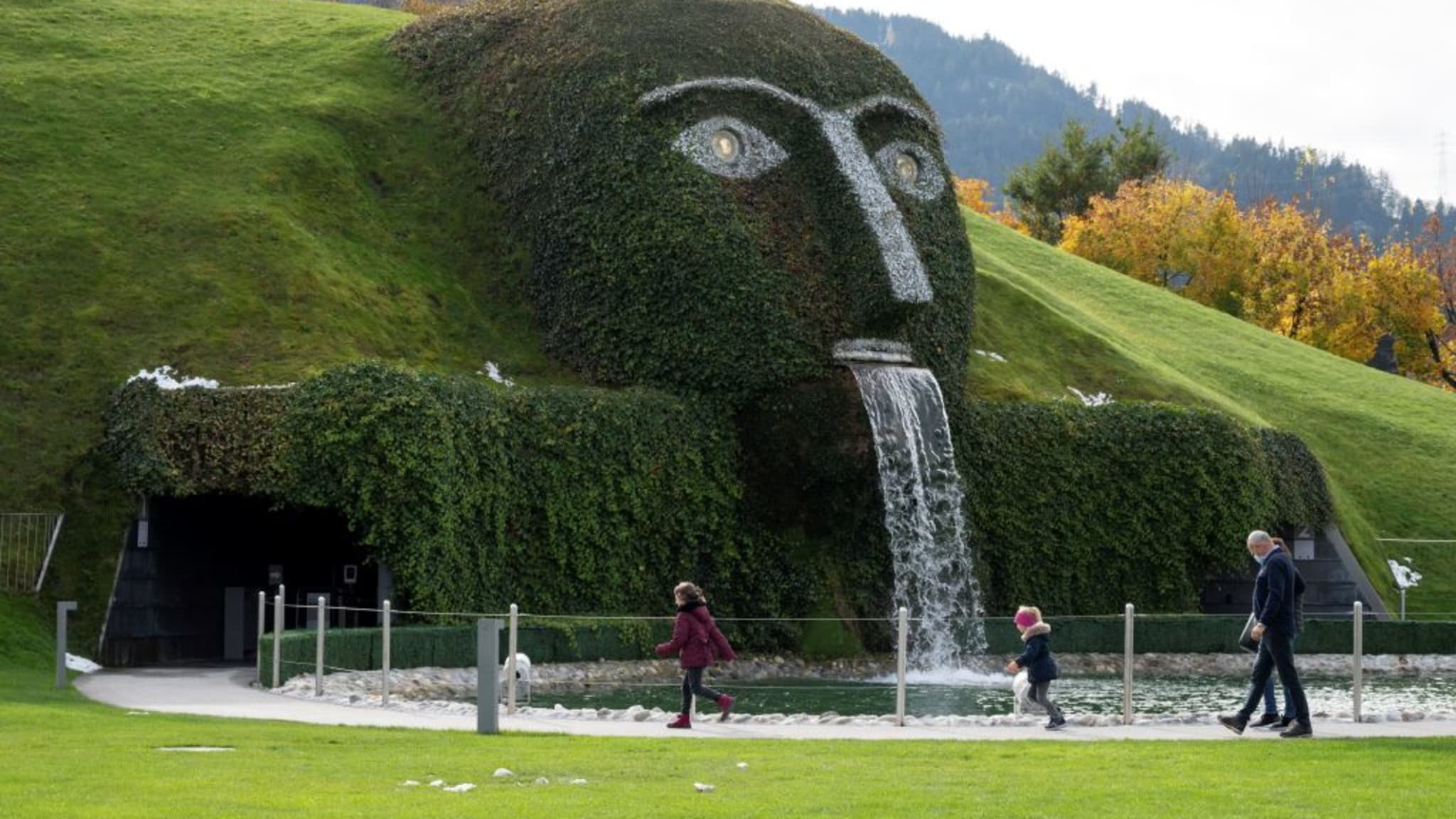 Eine Familie läuft an einem Brunnen vorbei in den Swarovski Kristallwelten in Tirol, Österreich. © JOE KLAMAR/AFP via Getty Images