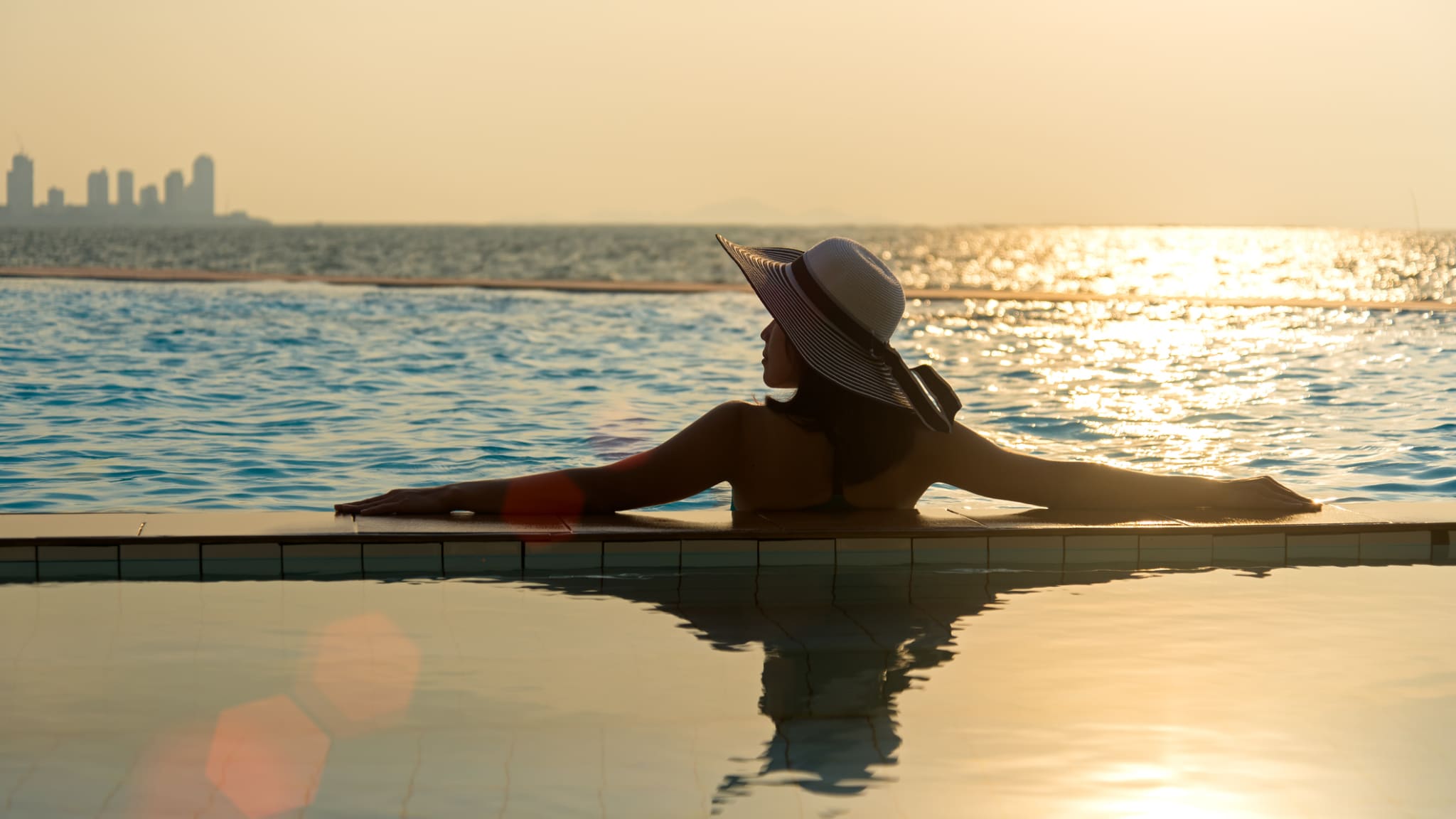 Eine Frau bei Sonnenuntergang in einem Pool.