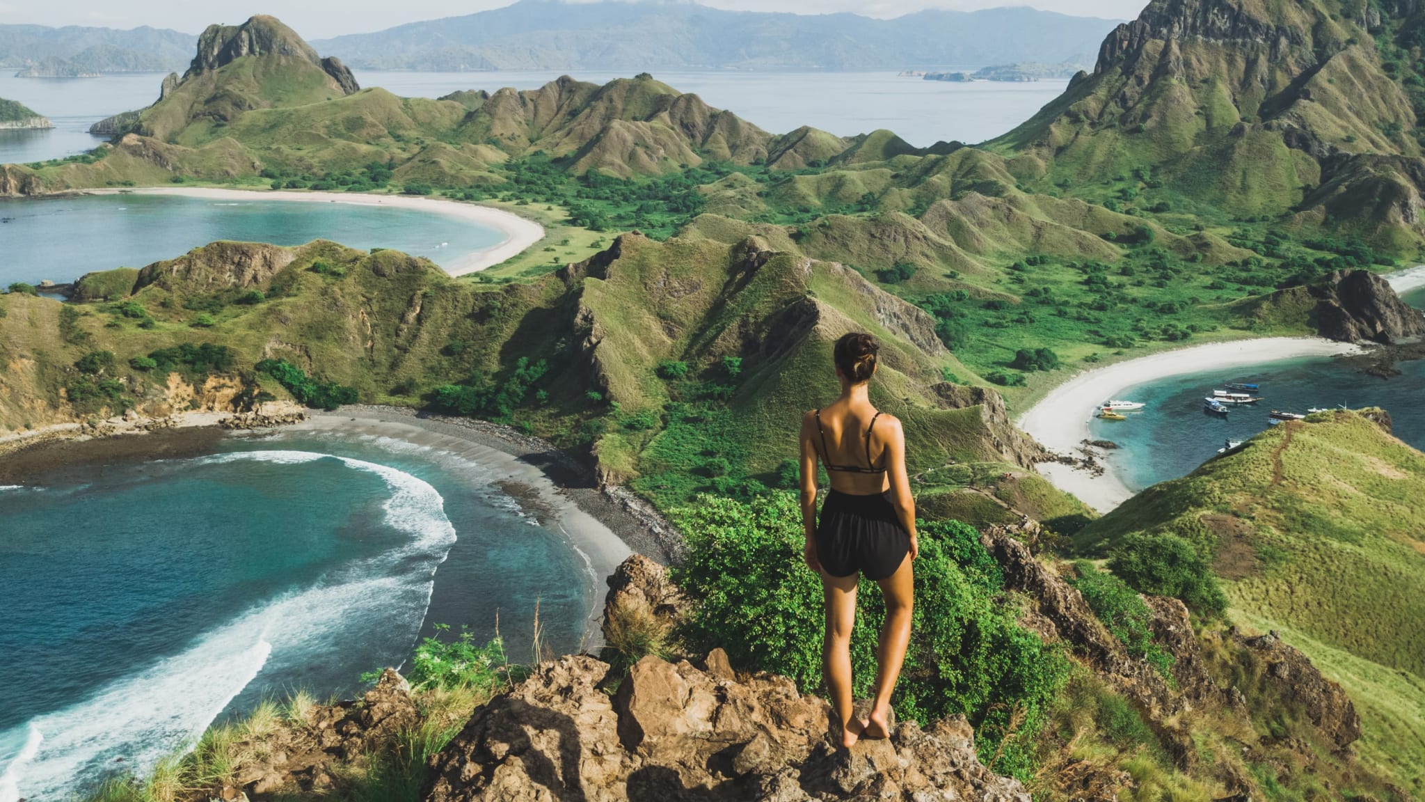 Eine Frau schaut auf eine Bucht im Komodo Nationalpark in Indonesien.