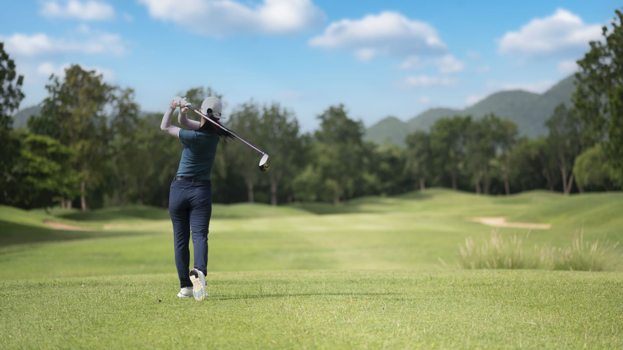 Eine Frau schlägt auf einem Golfplatz.