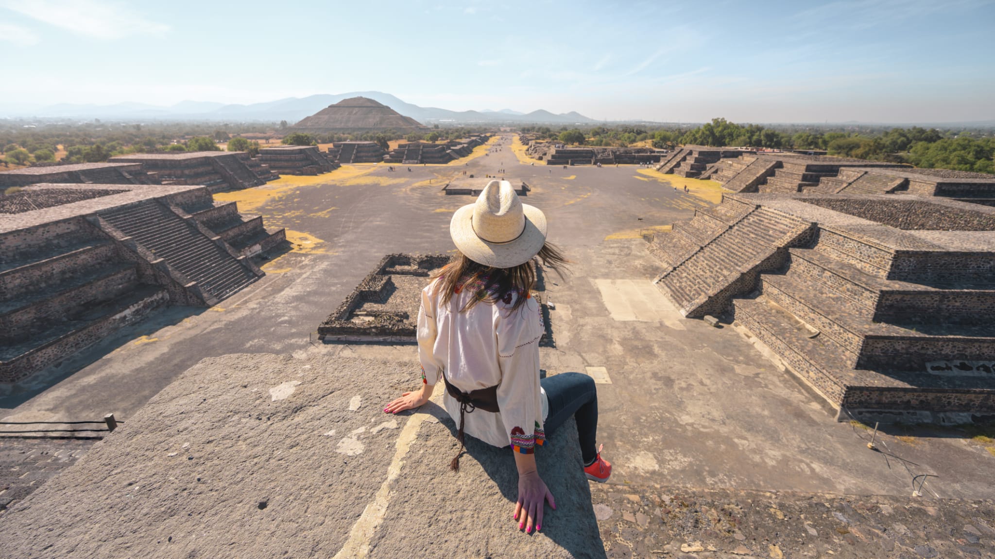 Eine Frau sitzt in der archäologischen Stadt Teotihuacan, Mexiko.
