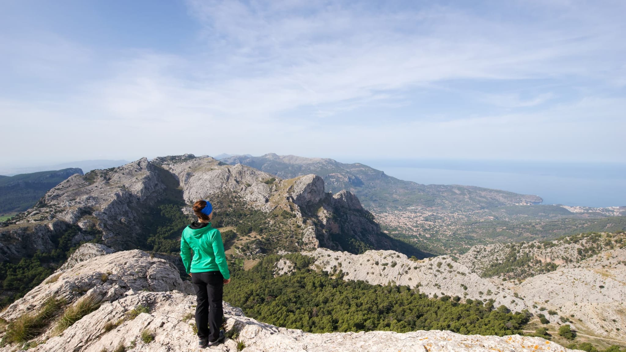 Eine Frau steht auf einem beg und blickt auf das Meer auf Mallorca.